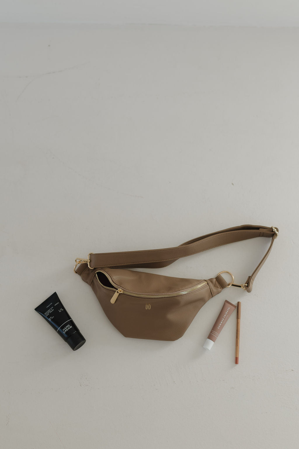 ff belt bag taupe displayed with beauty essentials, showcasing stylish and functional design for busy moms.