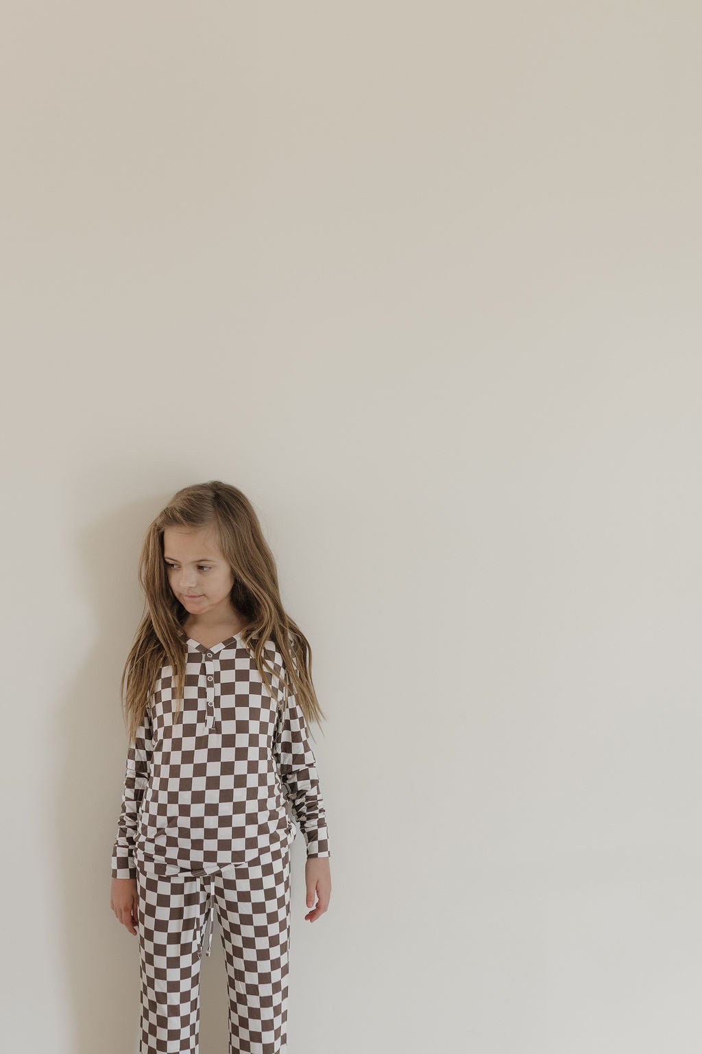 Youth flare bamboo pajamas Dutton in brown-and-white checkerboard on a child, perfect for comfort and style.