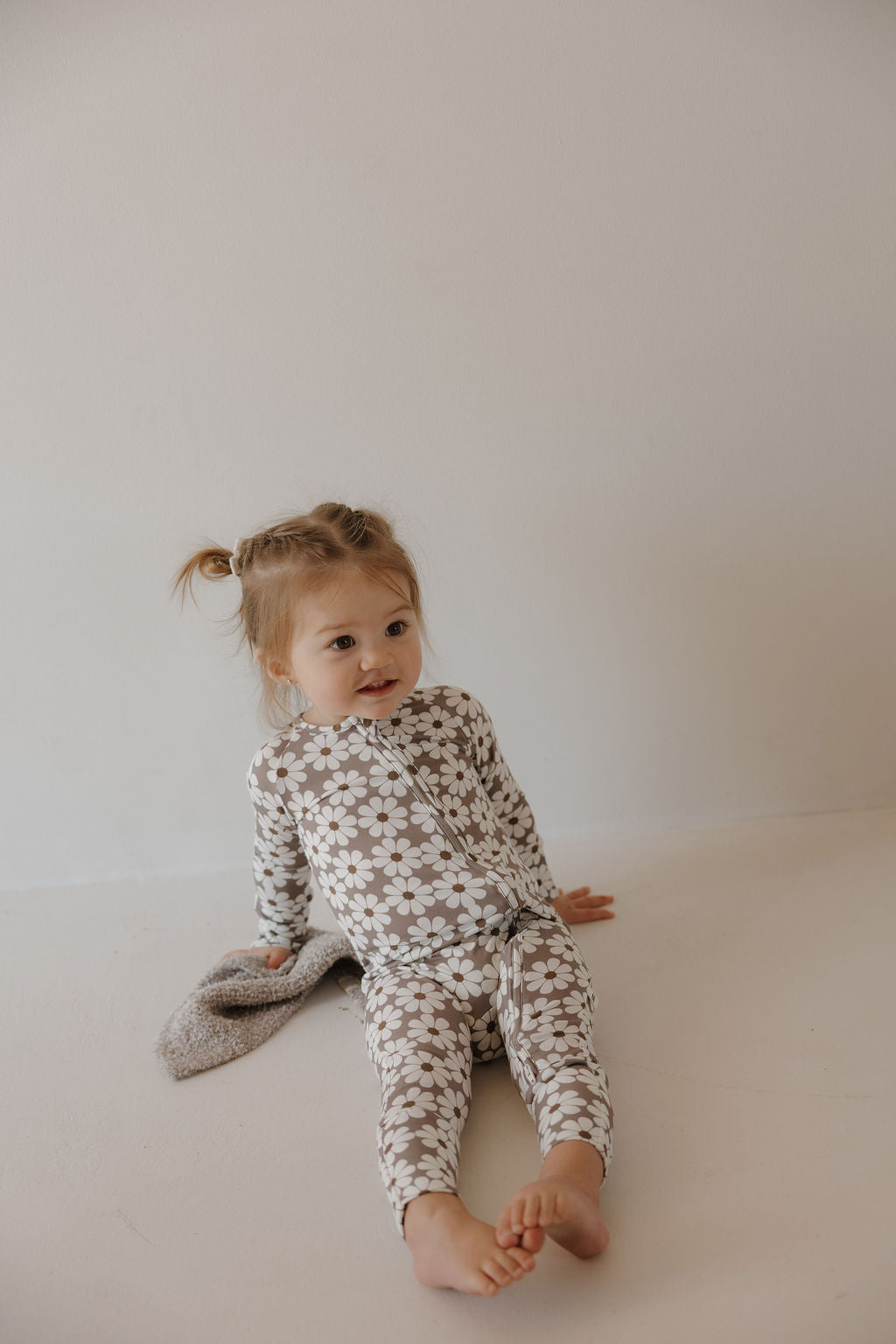 Baby in cozy bamboo zip pajamas darlin' with floral print, perfect for sleep and comfort.