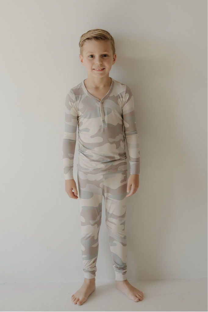 Child wearing bamboo two-piece pajamas camo set for comfort and playful mornings.
