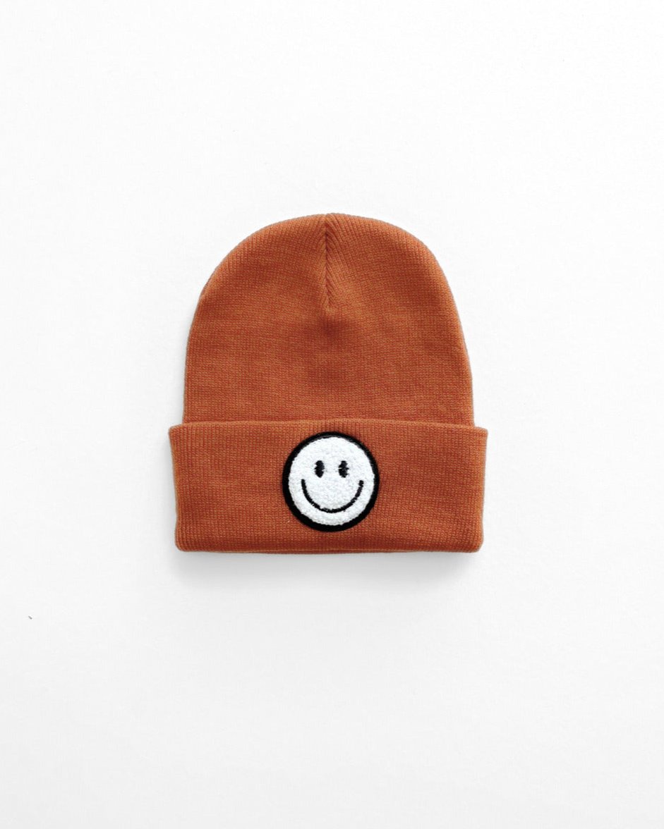 Rust Smiley Beanie with cheerful smiley face patch for cozy everyday wear.