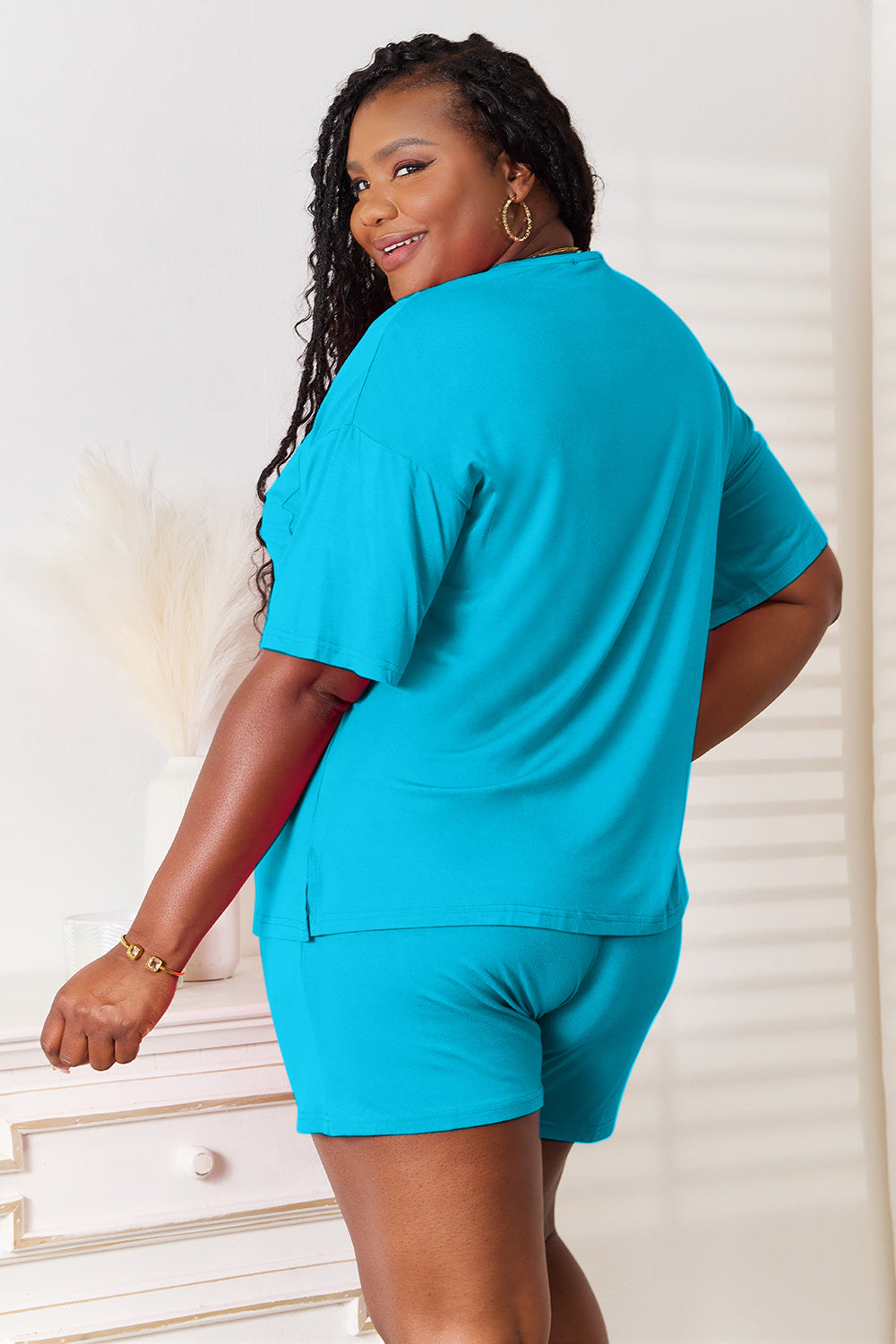 Woman wearing a turquoise Basic Bae soft top and shorts set, showcasing a relaxed half-sleeve design.