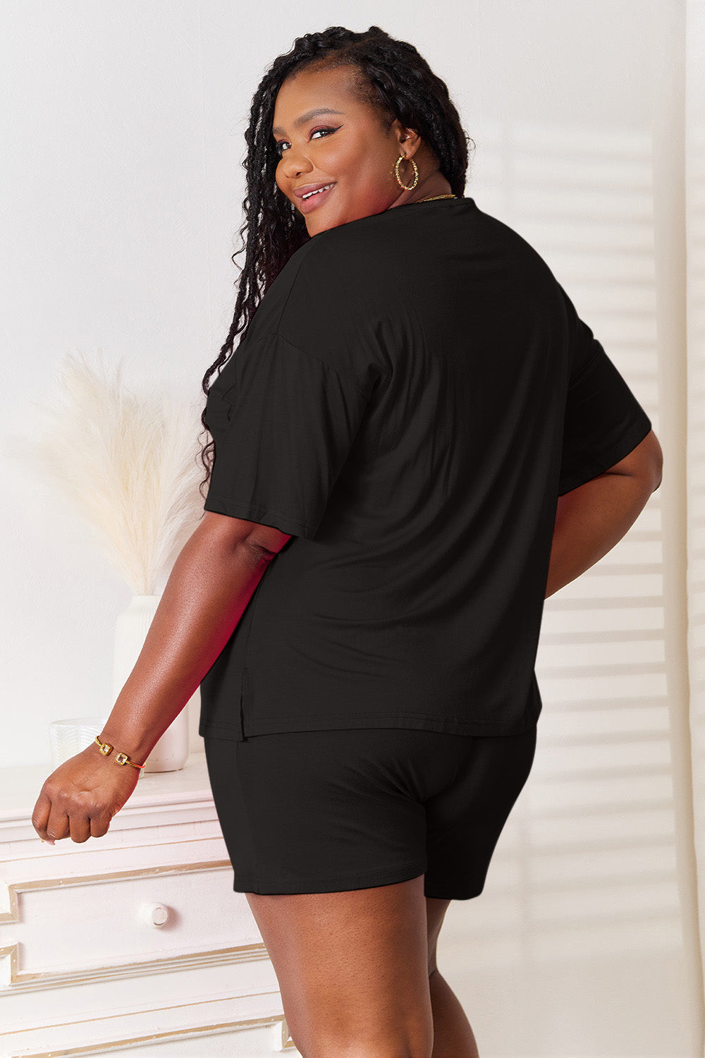 Back view of a model wearing a black half sleeve top and shorts set, showcasing comfort and effortless style.