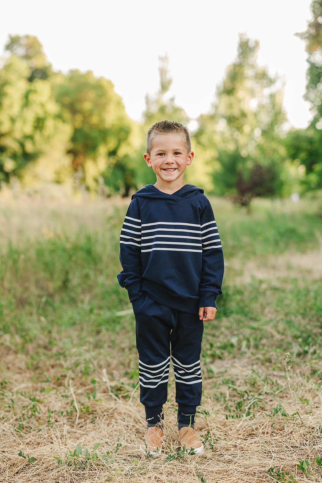 Cheerful boy in navy stripes hooded French terry set, perfect boys school outfit for pre-K and kindergarten.