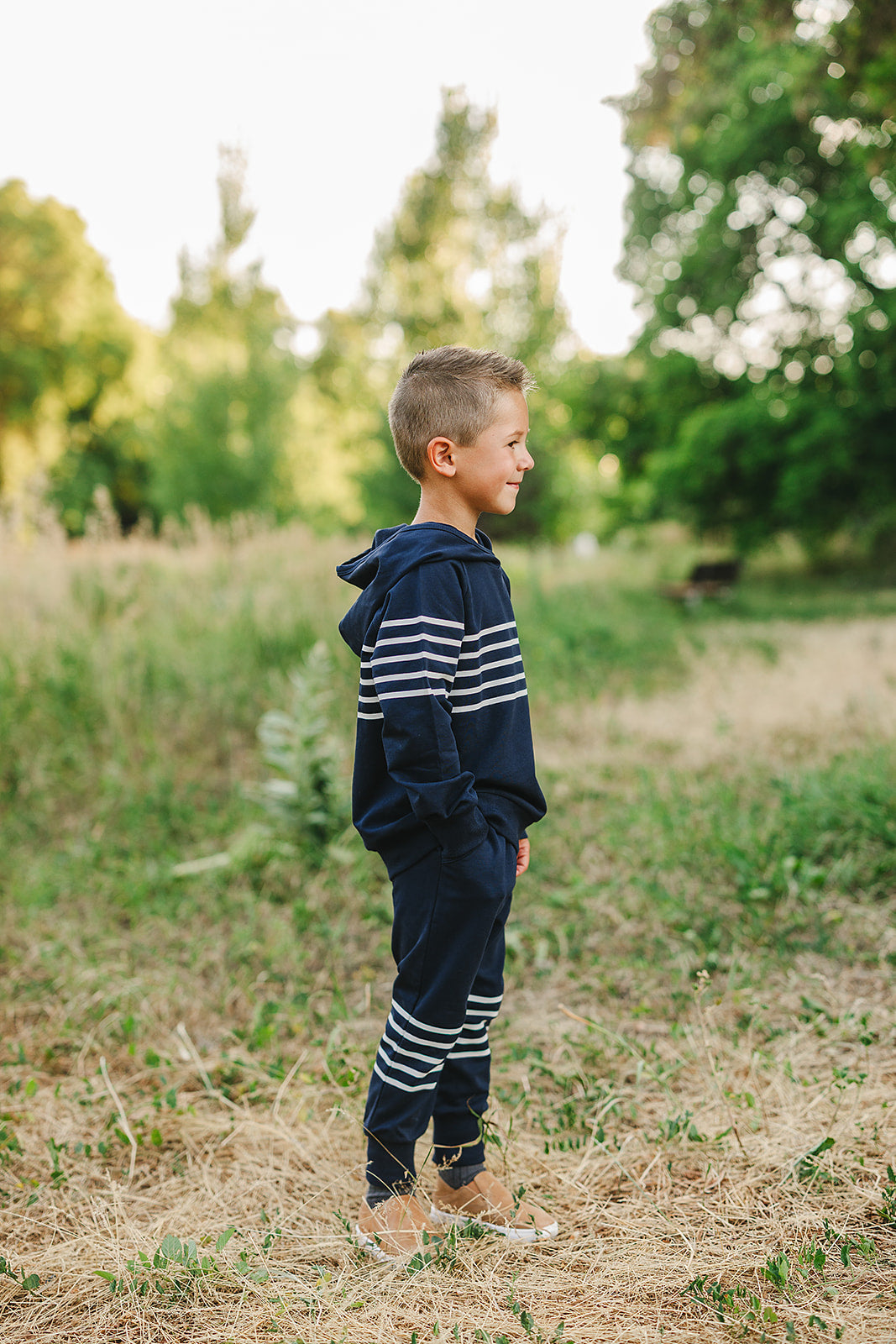 Boy wearing navy stripes hooded French terry set, ideal for school and outdoor play, showcasing comfort and style.