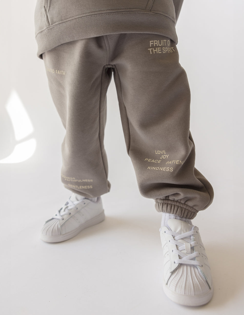 Child wearing Fruit of the Spirit kids sweatpant with inspirational words, showcasing comfort and style.