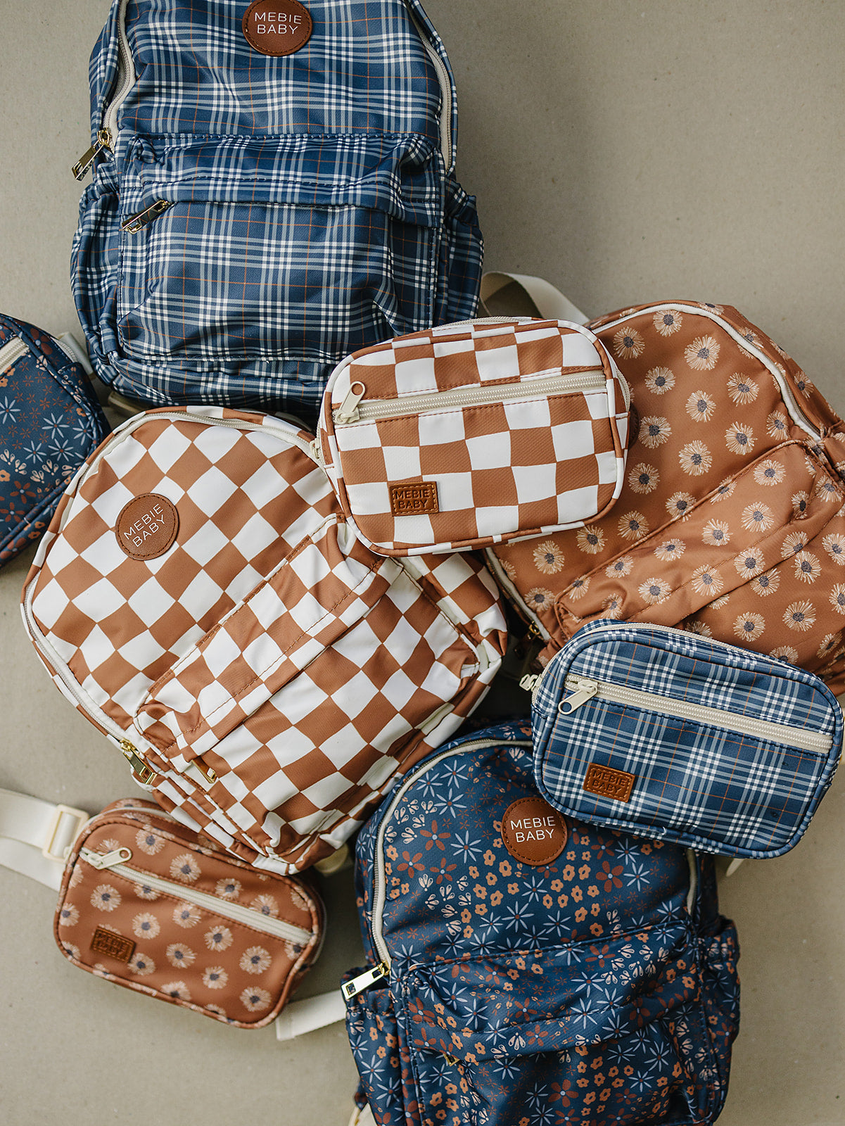 Colorful collection of mini backpacks and fanny packs featuring navy plaid and brown checkered patterns.