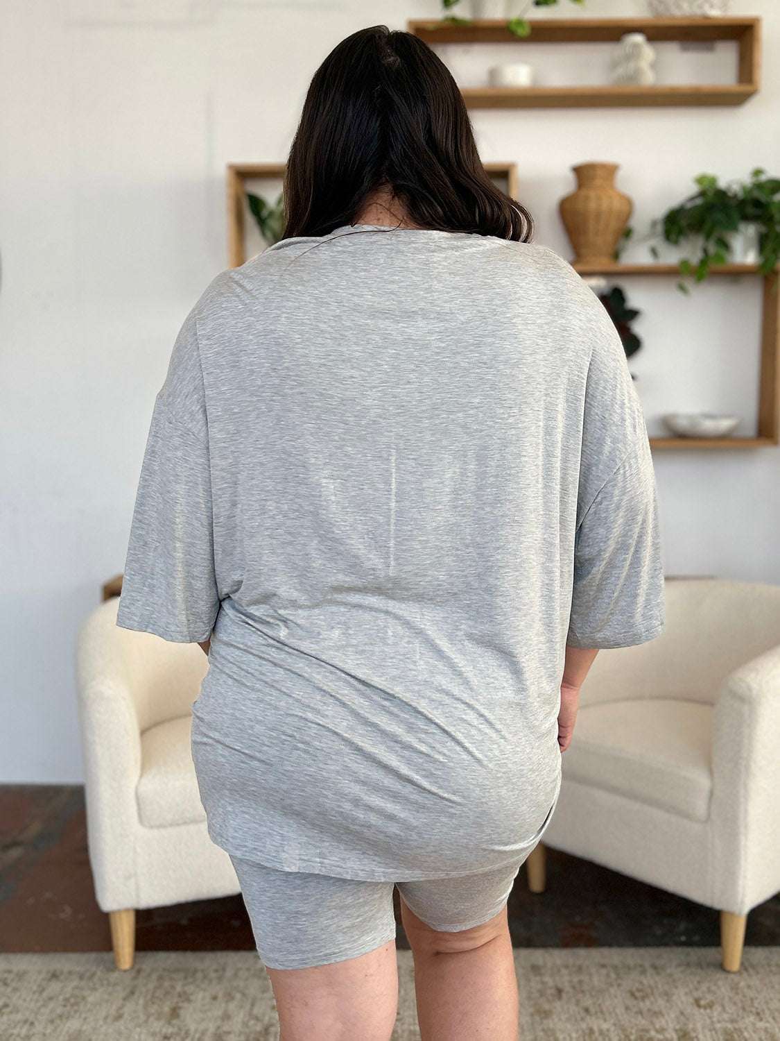 Back view of a model wearing a gray oversized bamboo t-shirt and matching shorts set, showcasing relaxed, casual style.