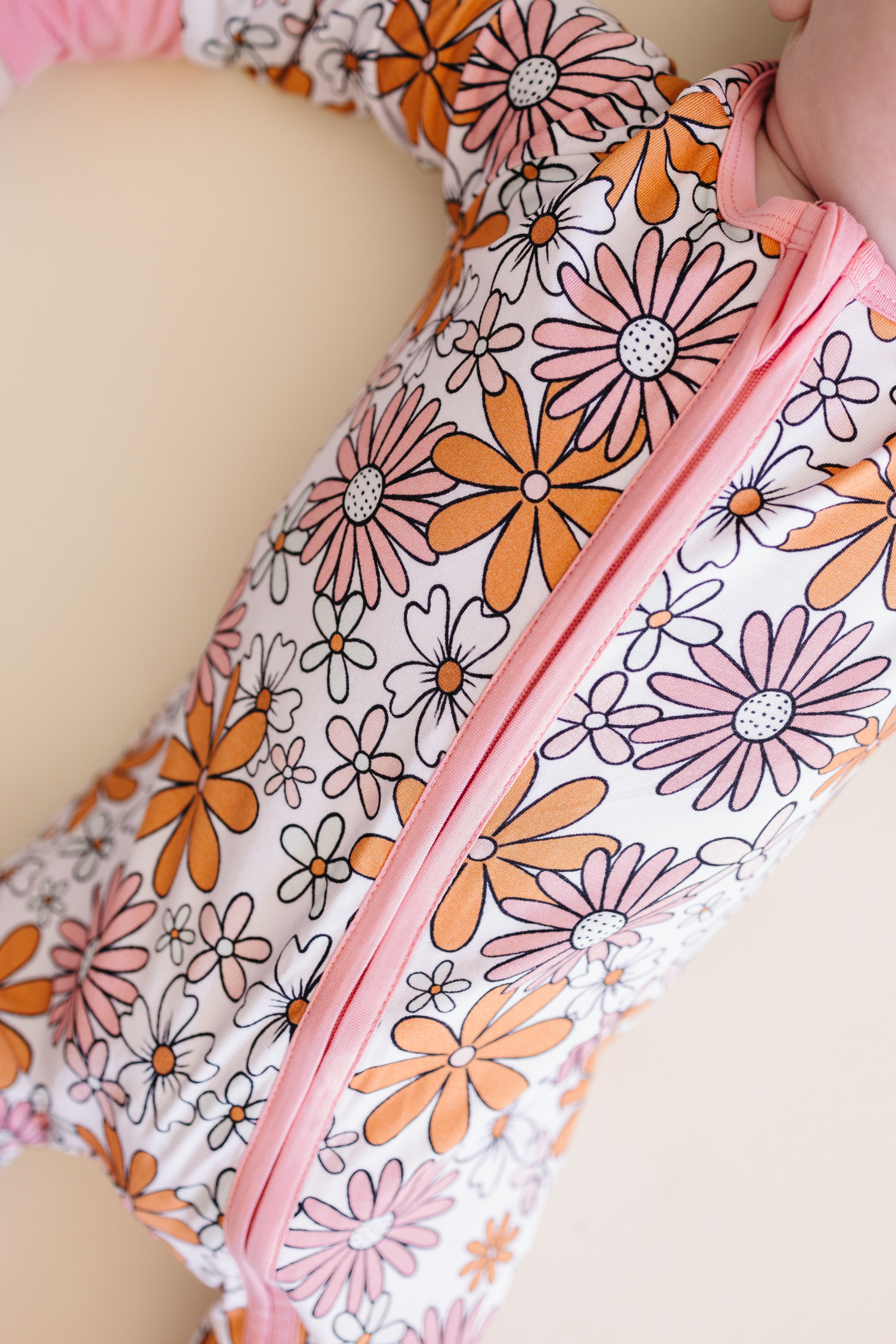 Bamboo zip baby romper featuring a vibrant retro floral print in warm tones on a soft fabric.
