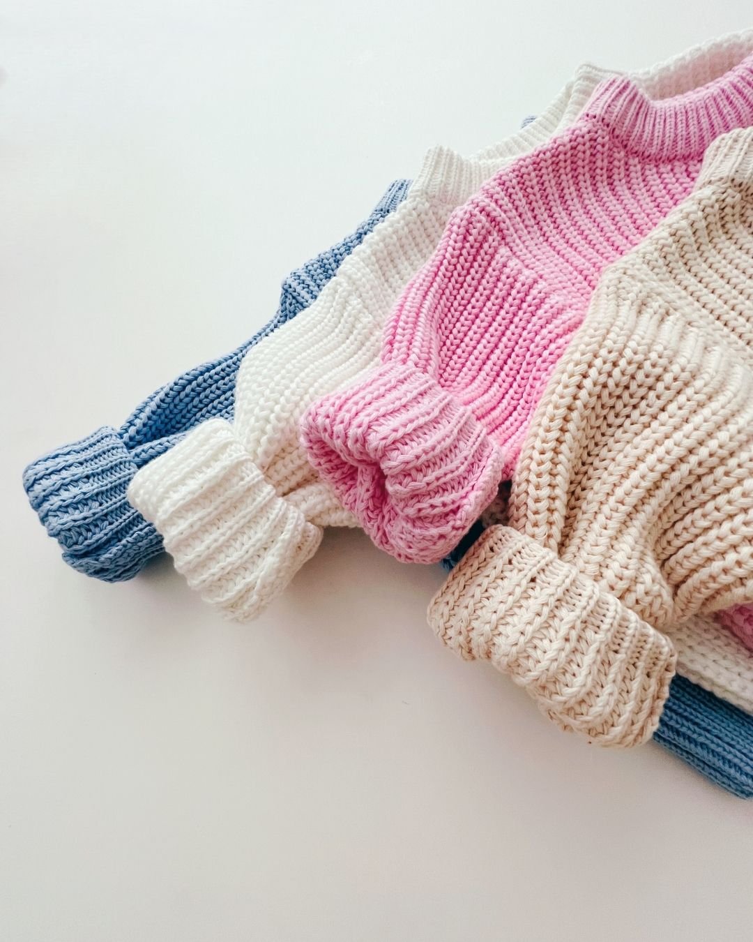 Colorful Chunky Knit Sweaters in pink, white, blue, and beige showcasing their cozy texture and relaxed fit.