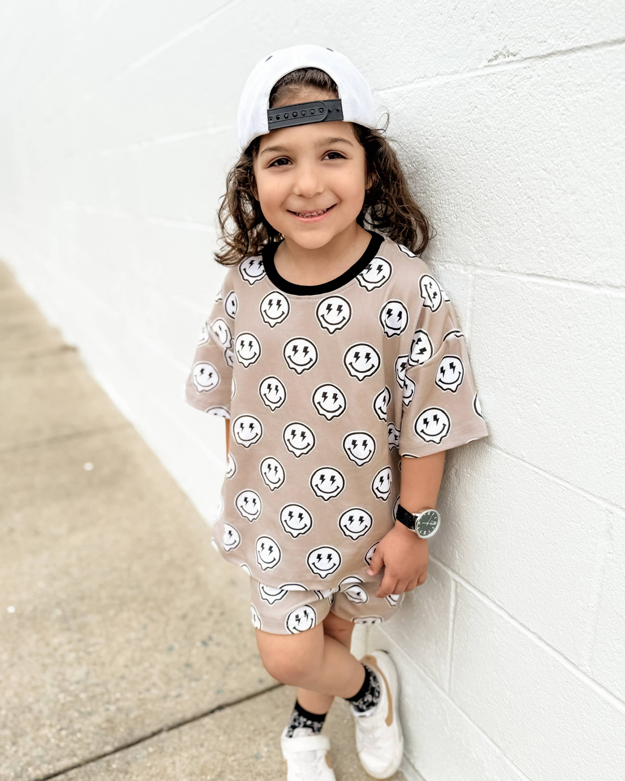 Toddler wearing Electric Drippy shorts set with smiley face print, showcasing streetwear style and youthful energy.