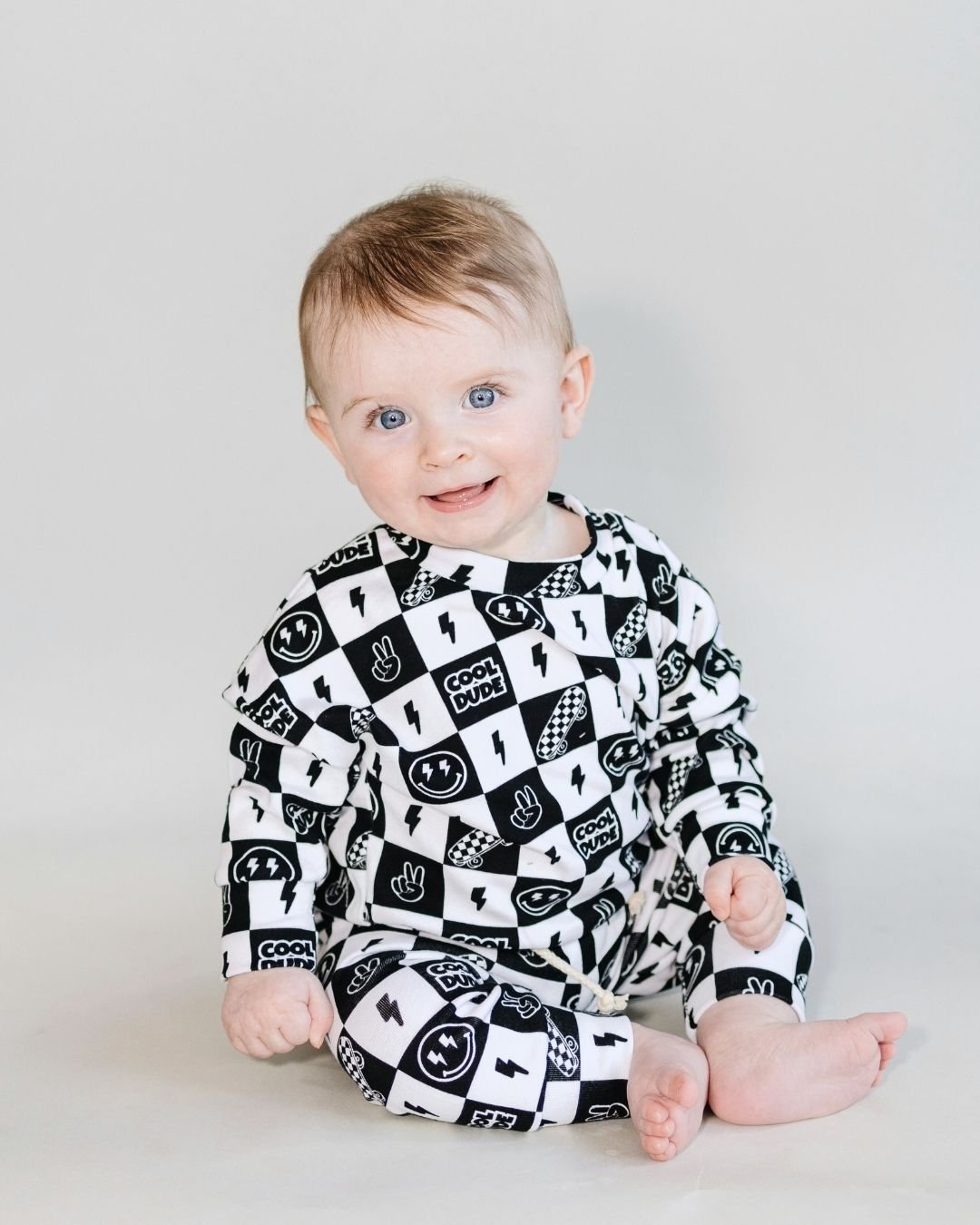 Baby wearing the Cool Dude Jogger Set, a stylish two-piece lounge outfit with playful black and white graphics.