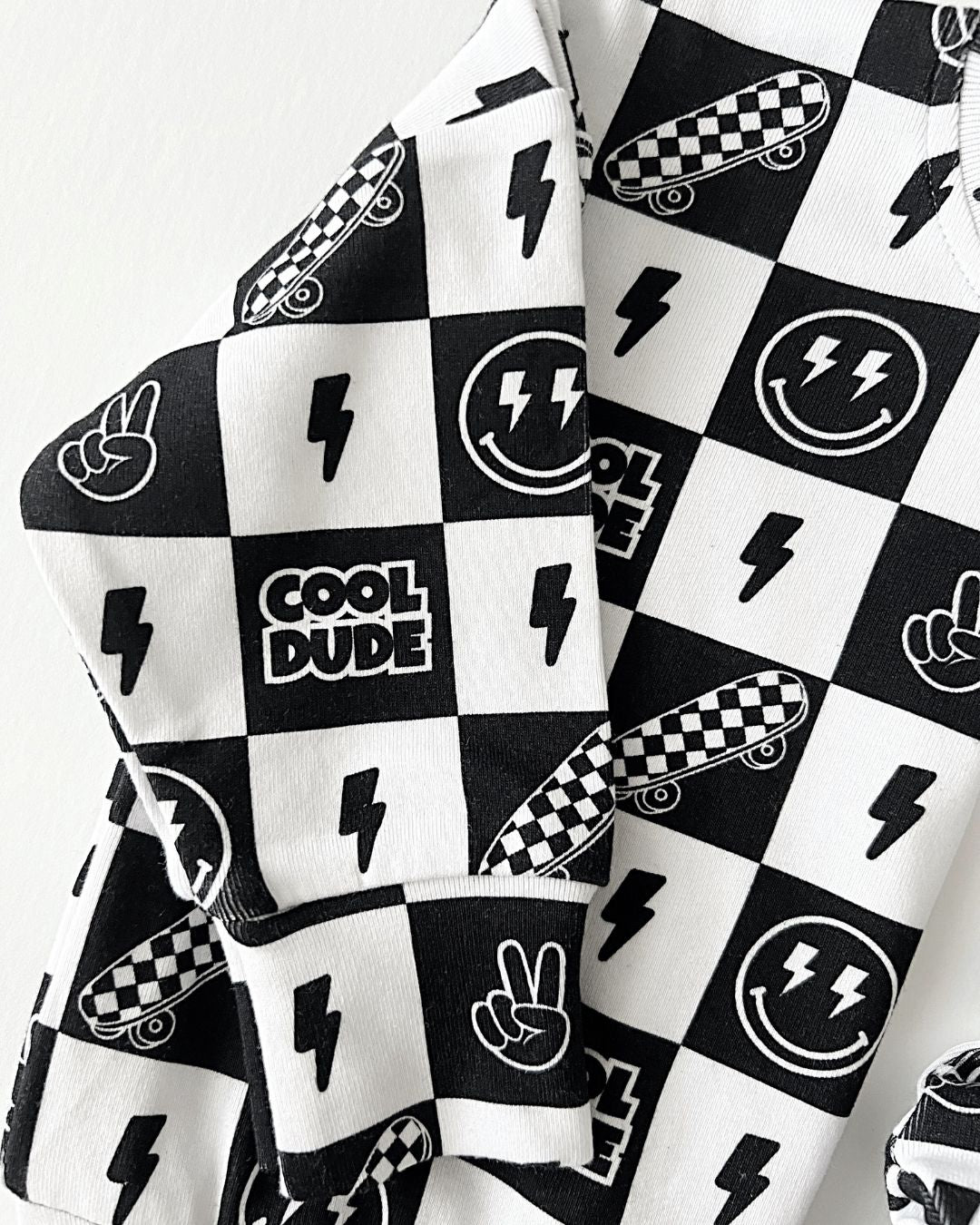 Close-up of Cool Dude graphic print on jogger set, featuring playful designs in black and white.