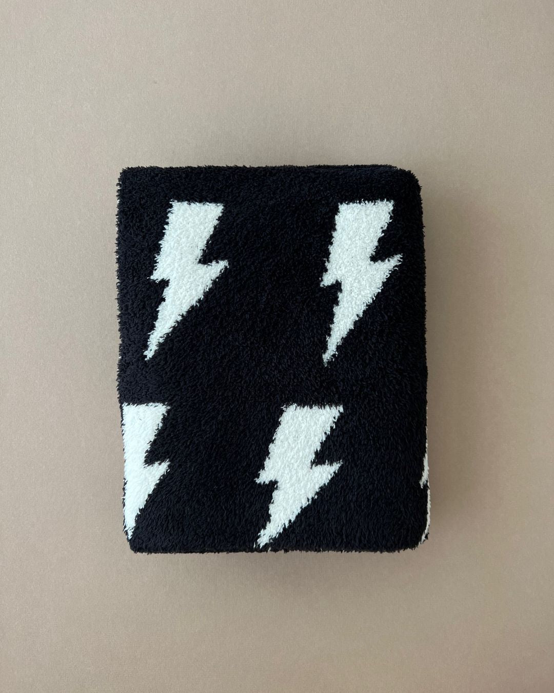 Lightning Bolt Fuzzy Blanket in black with white lightning bolt pattern, ideal for baby and toddler comfort.