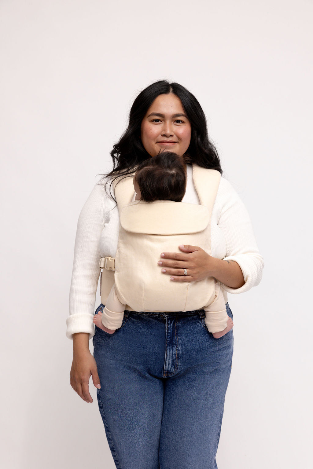 Sparrow Aerial Carrier in vanilla beige, featuring color-matched straps, worn by a woman with a baby.