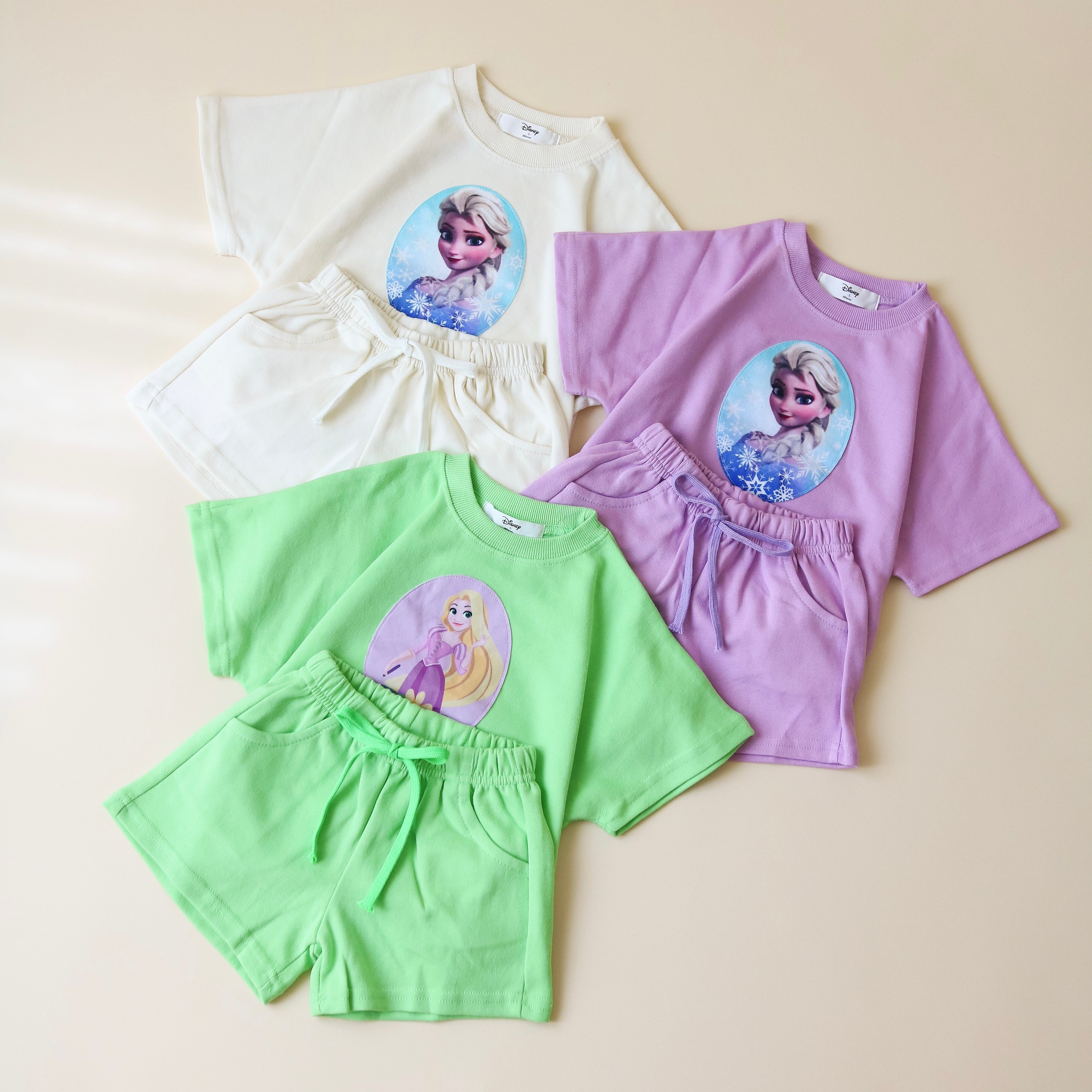Toddler girl princess short set featuring t-shirts and shorts in pastel colors with iconic princess designs.