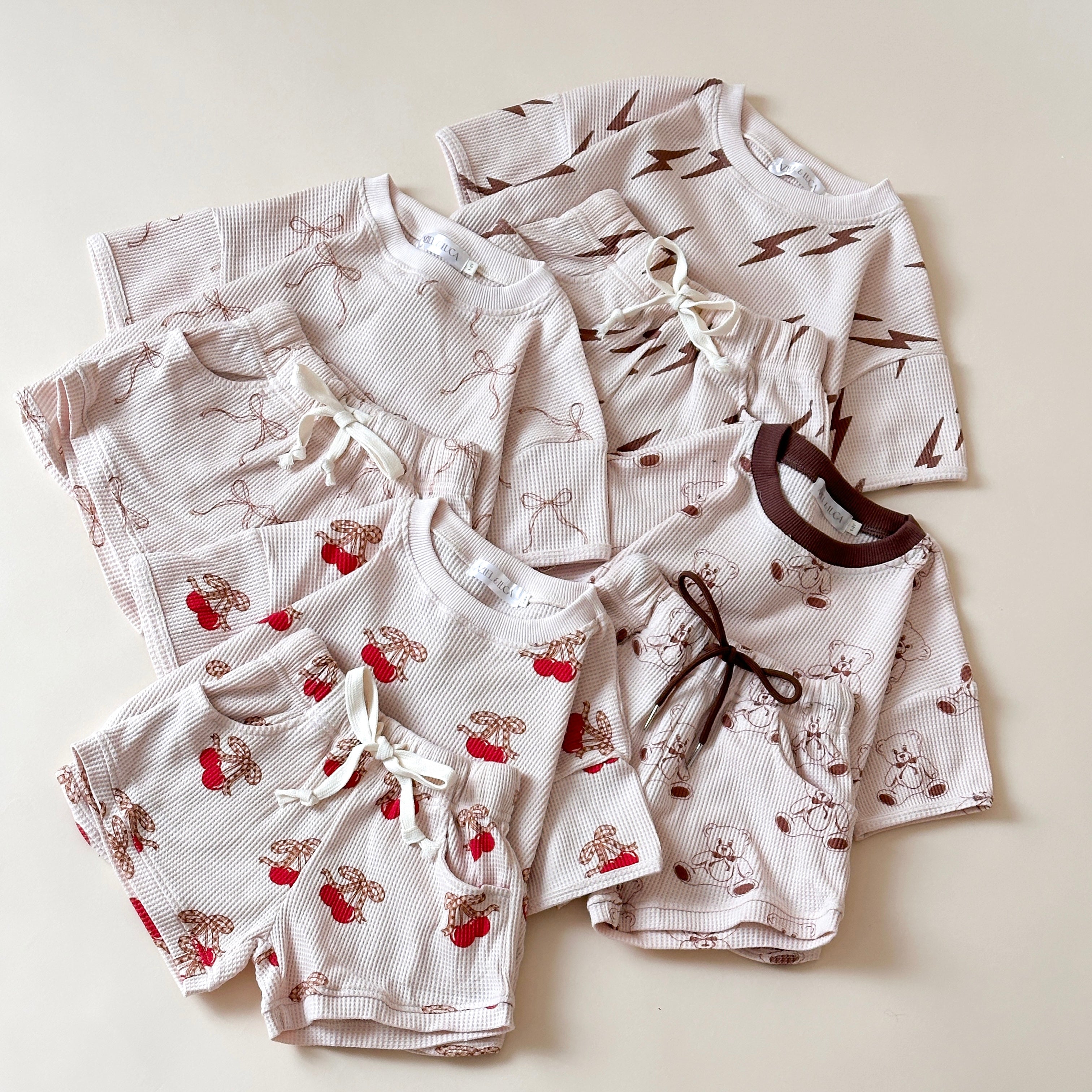 Cute baby waffle sets featuring bolt, bow, cherry, and bear prints, perfect for summer wear.