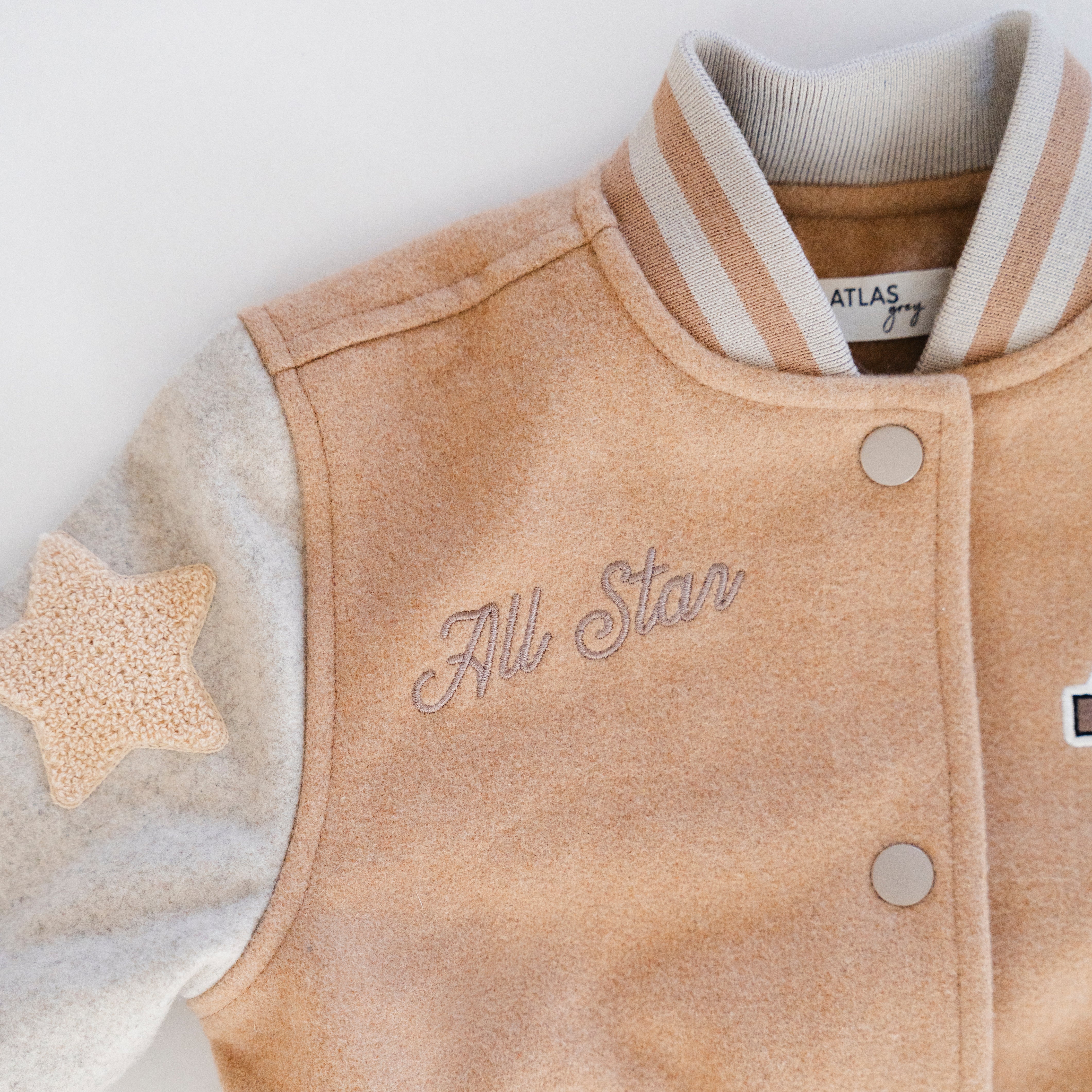 Letterman Jacket featuring tan body and contrast sleeves with star patch and All Star embroidery for kids.