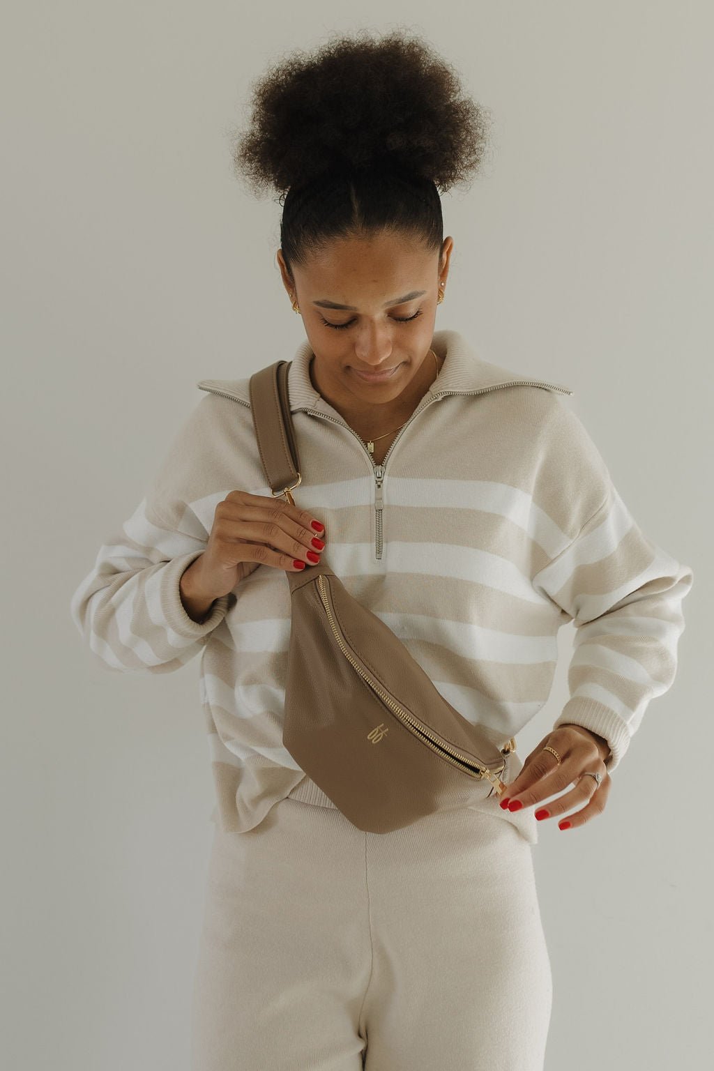 Model wearing ff belt bag taupe with chic gold hardware, showcasing hands-free functionality for busy moms.