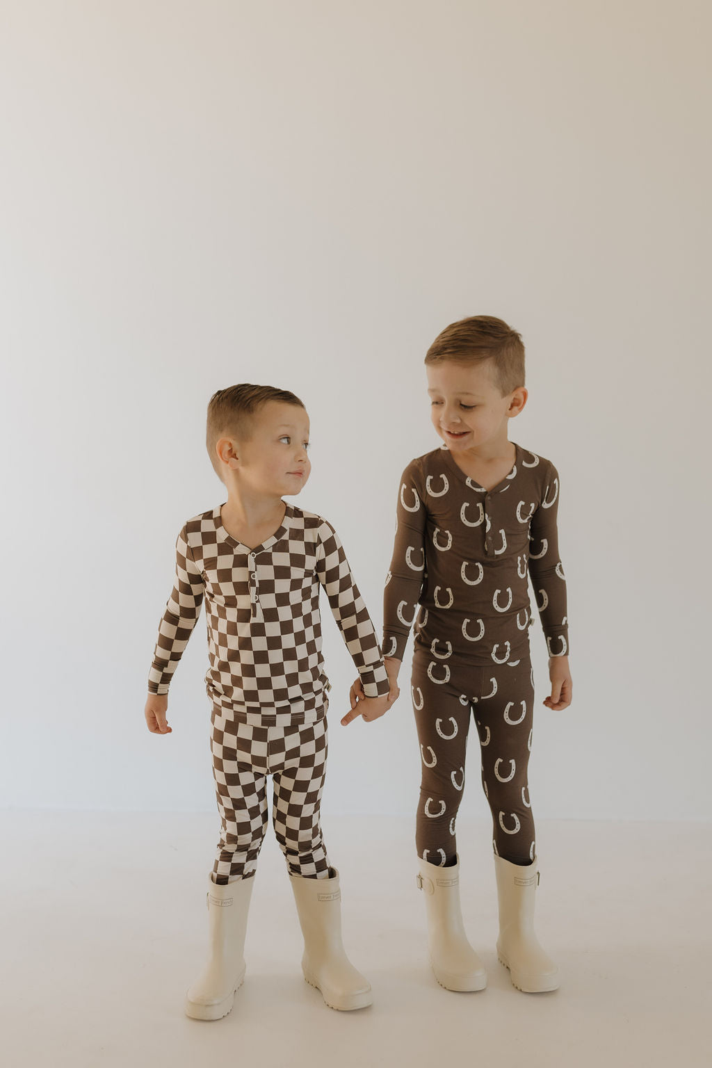 Two boys in bamboo two-piece pajamas 'Giddy Up' with fun prints, ready for cozy adventures.