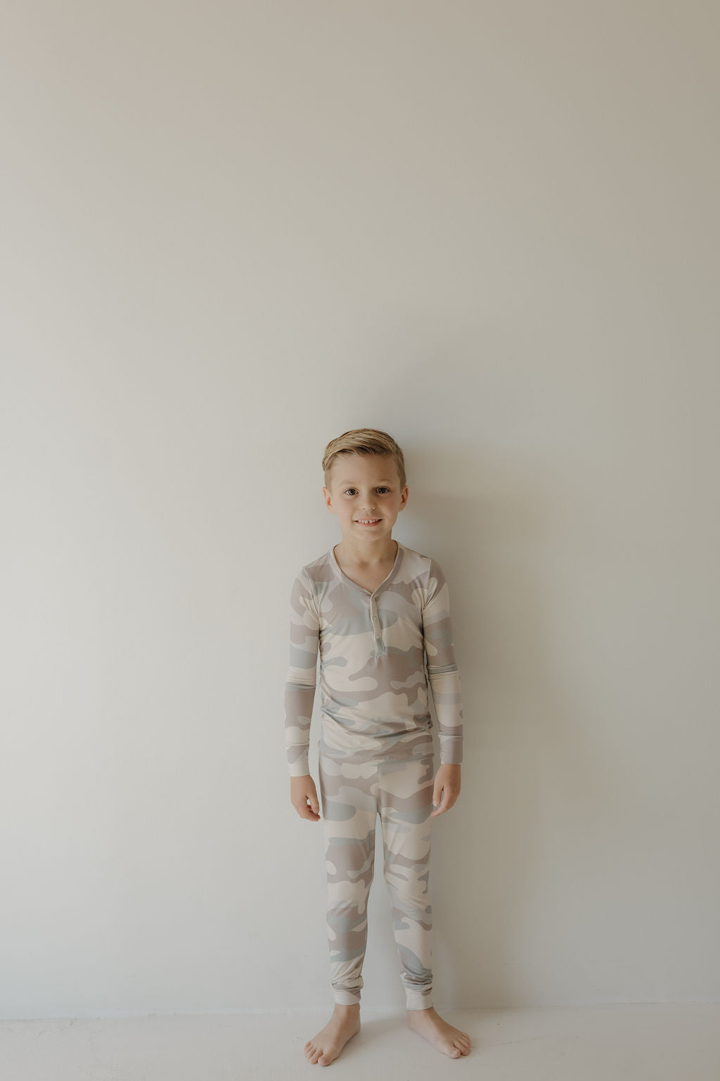 Child wearing bamboo two-piece pajamas camo set, perfect for comfort during rest and play.
