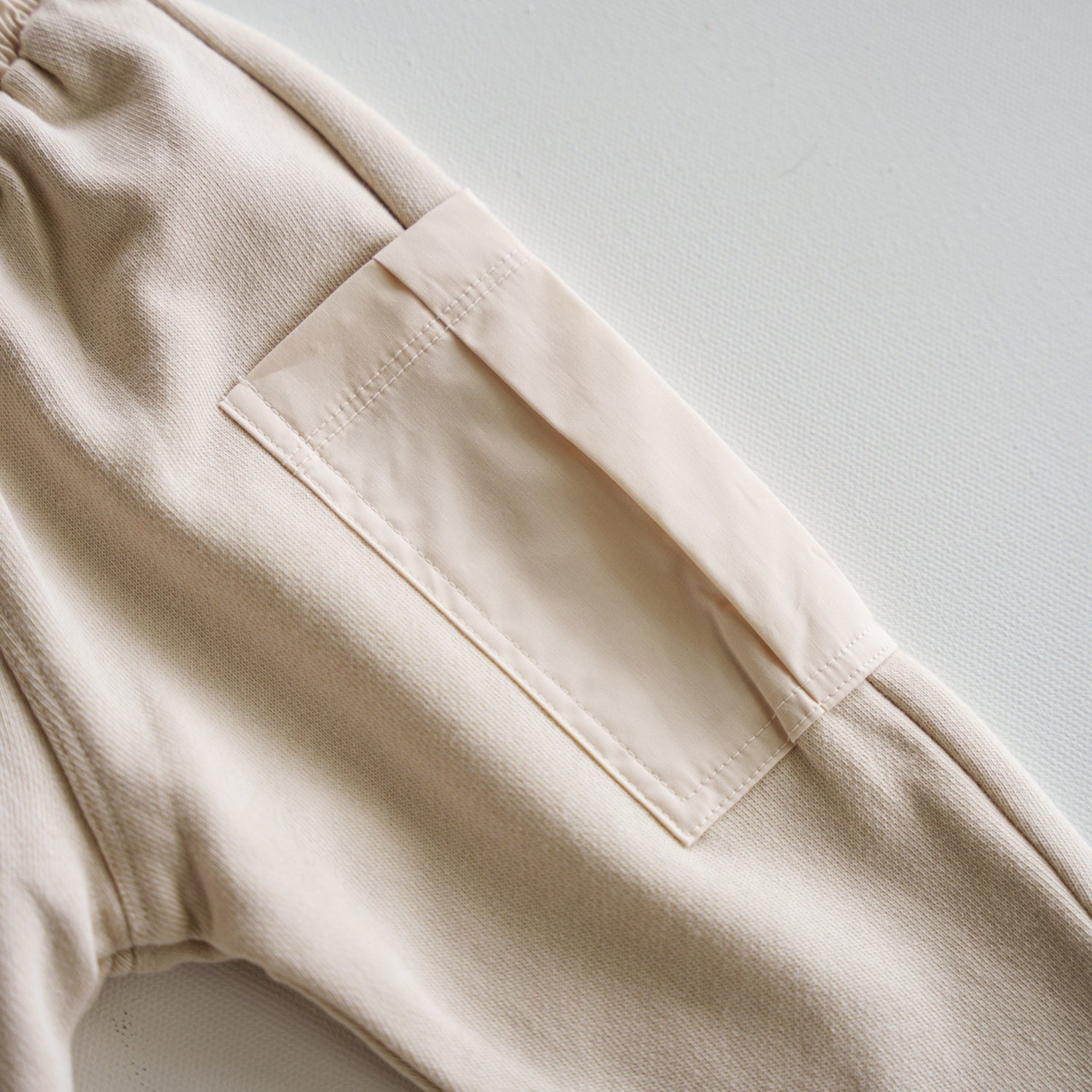 Close-up of the cargo pocket on the Cargo Wideleg Pant in soft neutral tones.