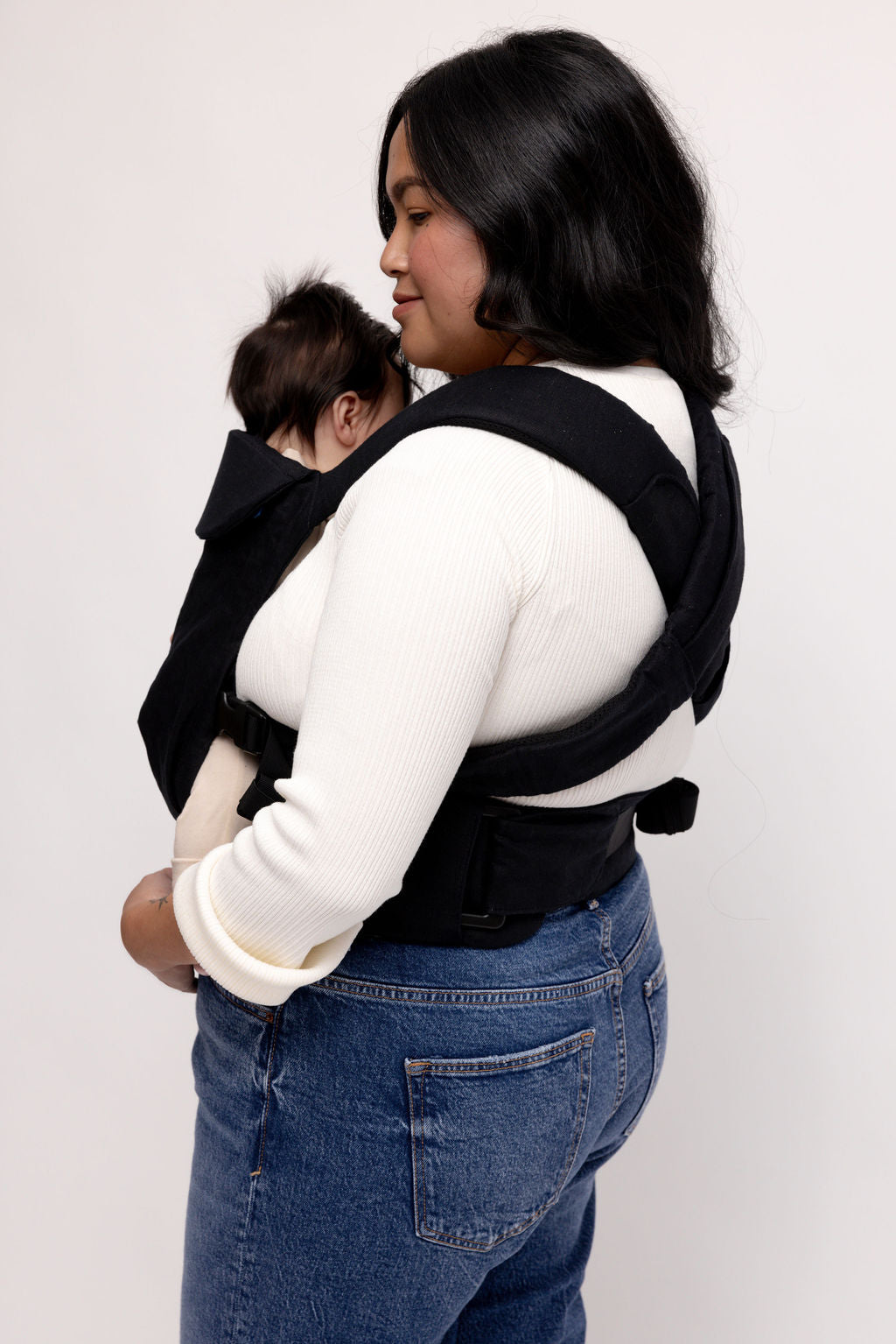 Mom using the Raven Aerial Carrier with a baby, showcasing its sleek design and ease of use.