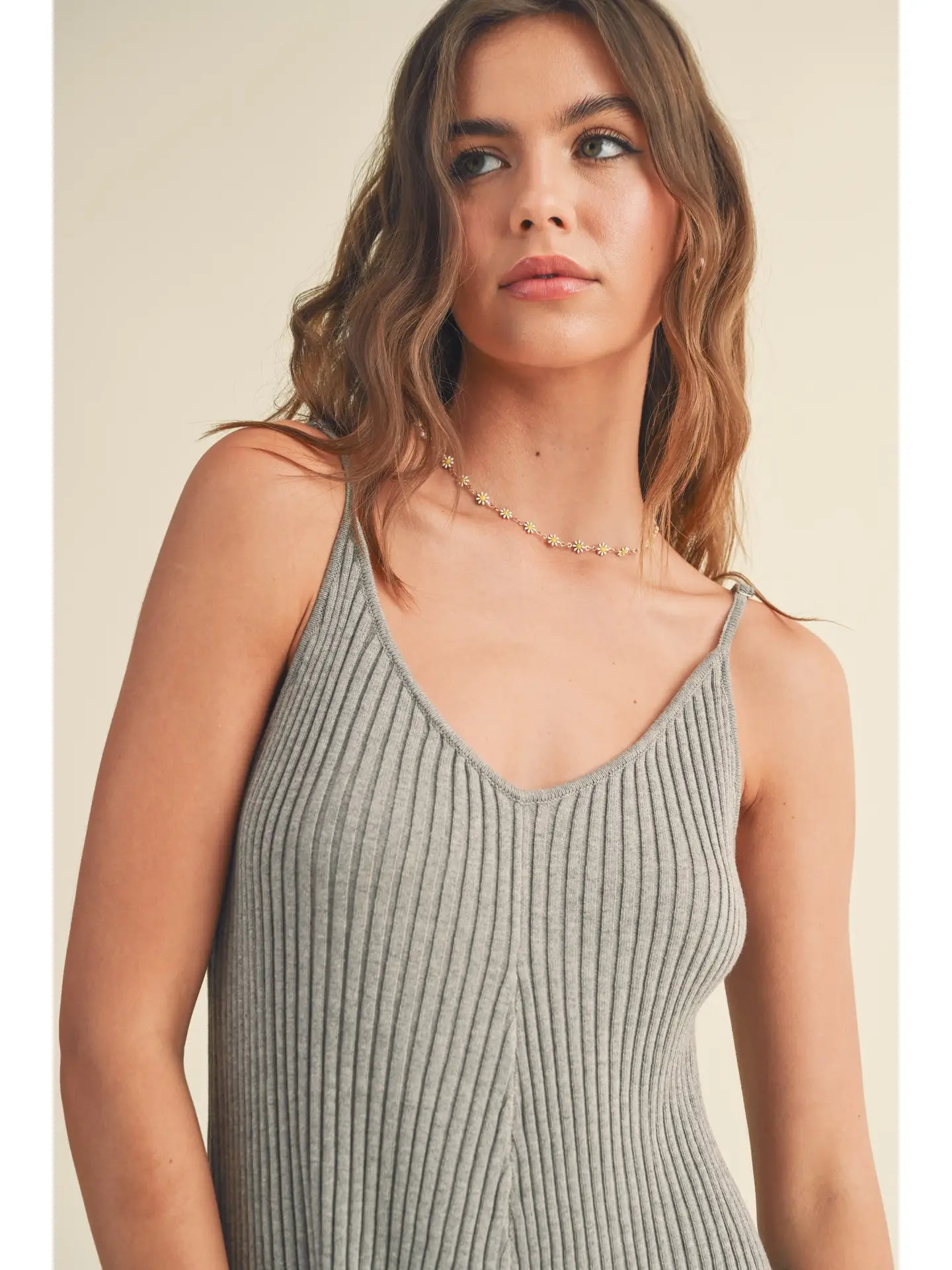 Woman wearing a Ribbed Knitted Romper in grey, showcasing its soft fabric and stylish design.