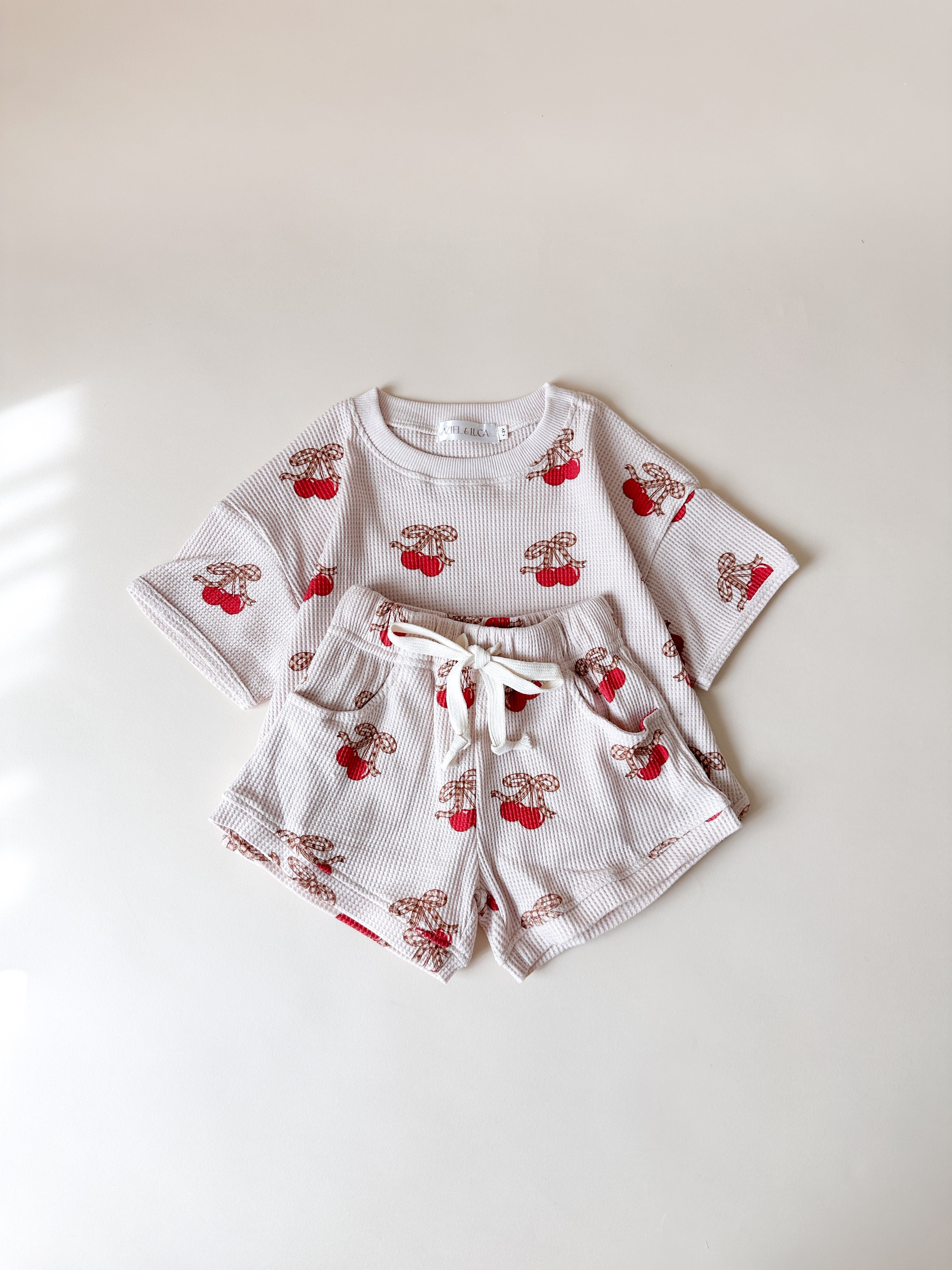 Printed waffle baby set featuring cherry and bear prints, perfect for summer wear.