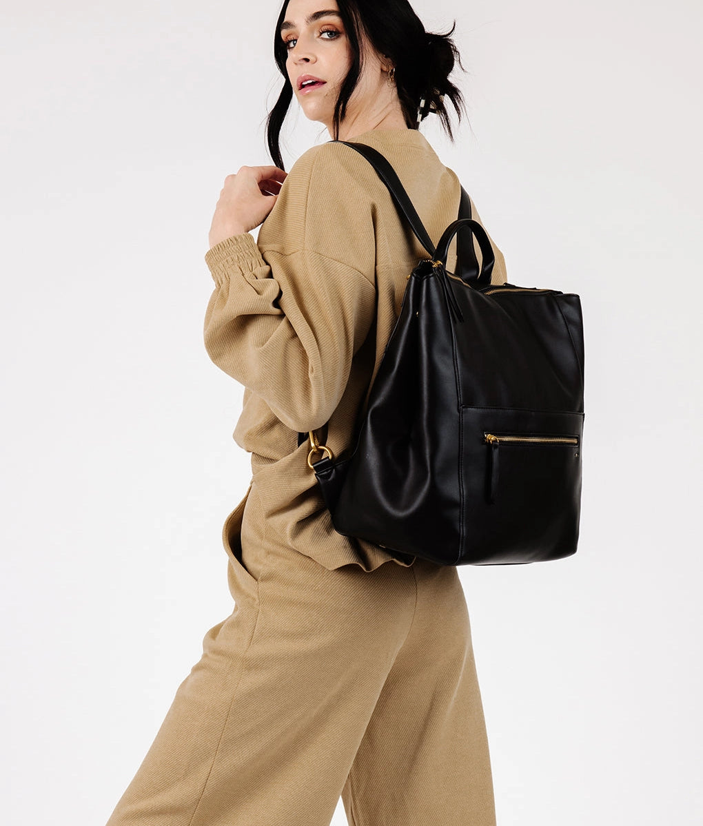 Square Diaper Bag Backpack in matte faux leather, worn as a backpack by a model in a stylish outfit.