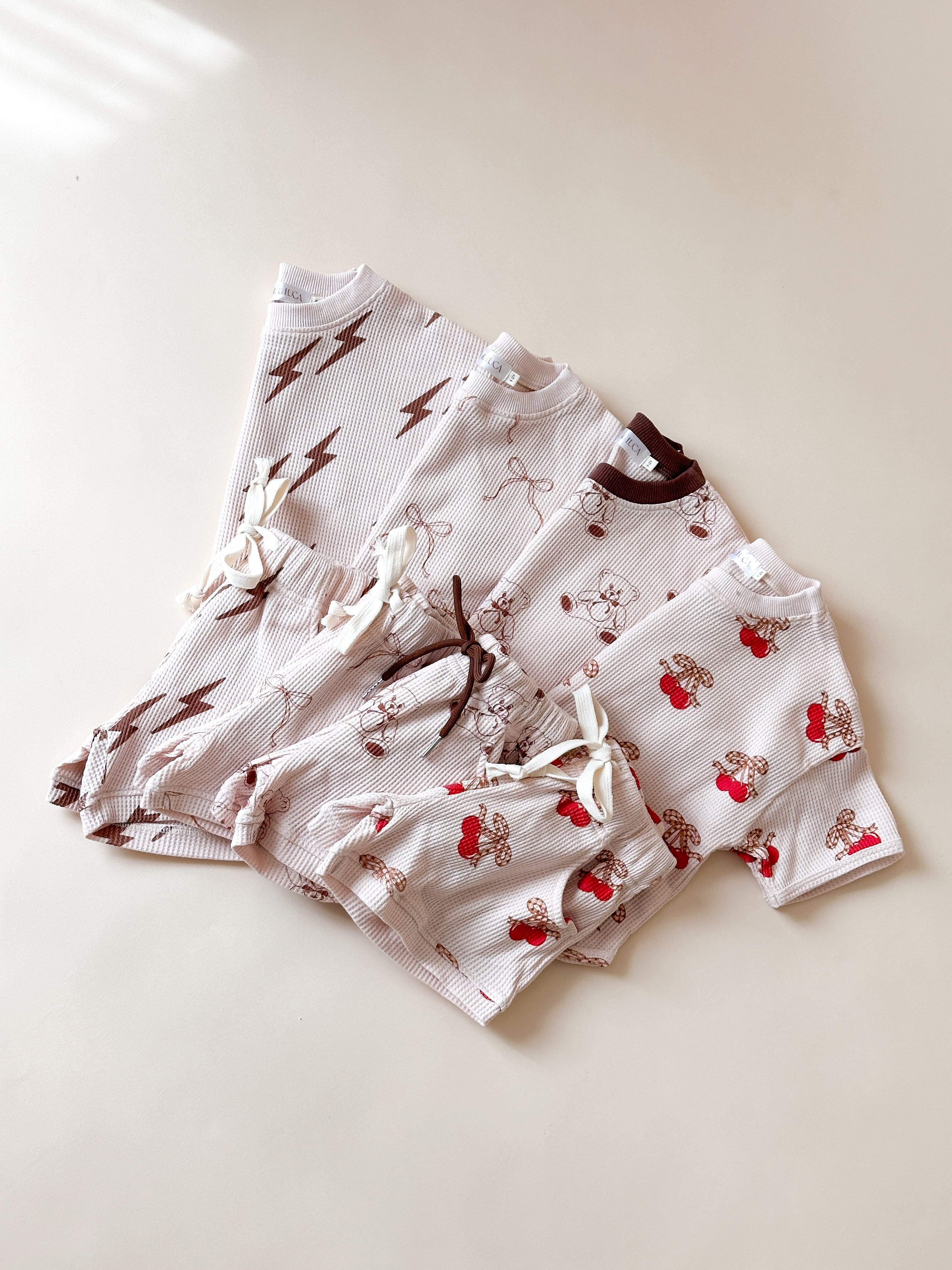 Adorable Bolt, Bow, Cherry, and Bear Print Baby Waffle Sets in soft material, perfect for summer wardrobe.