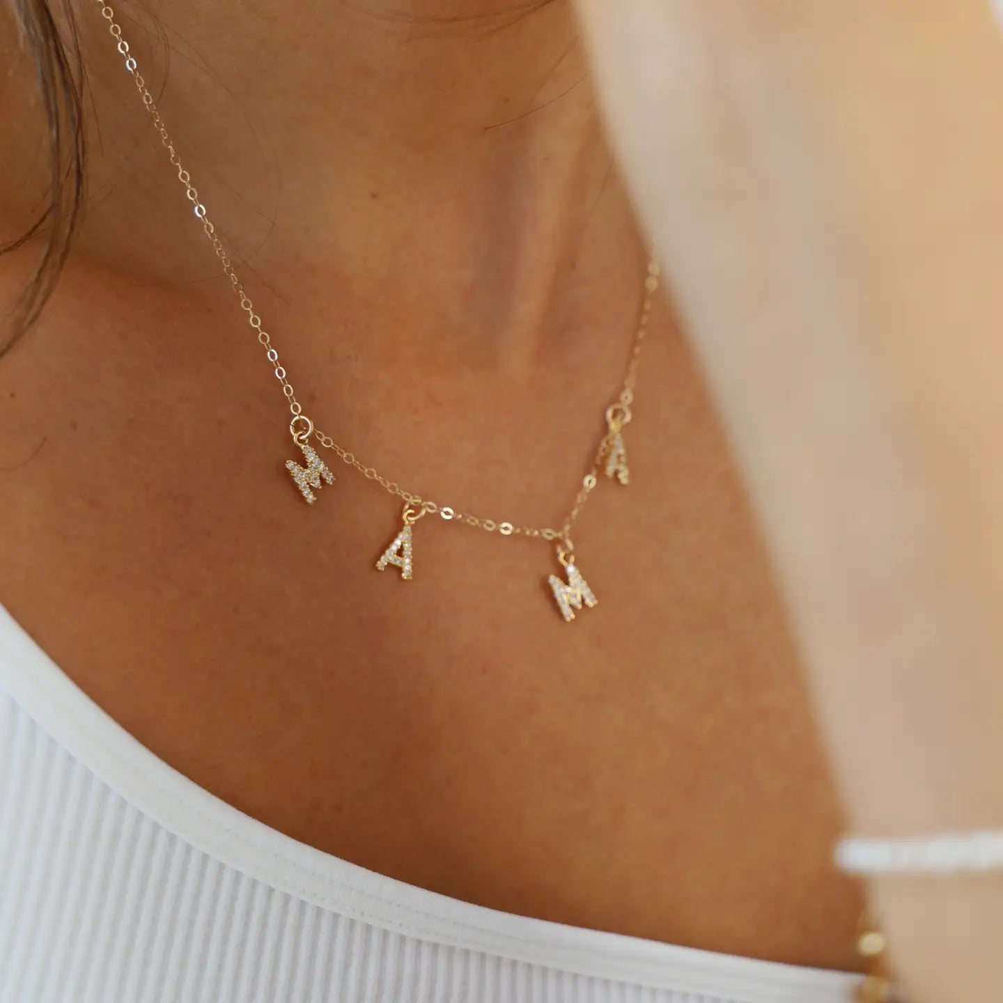 Gold mama necklace featuring a dainty design with charm letters, perfect for everyday wear.