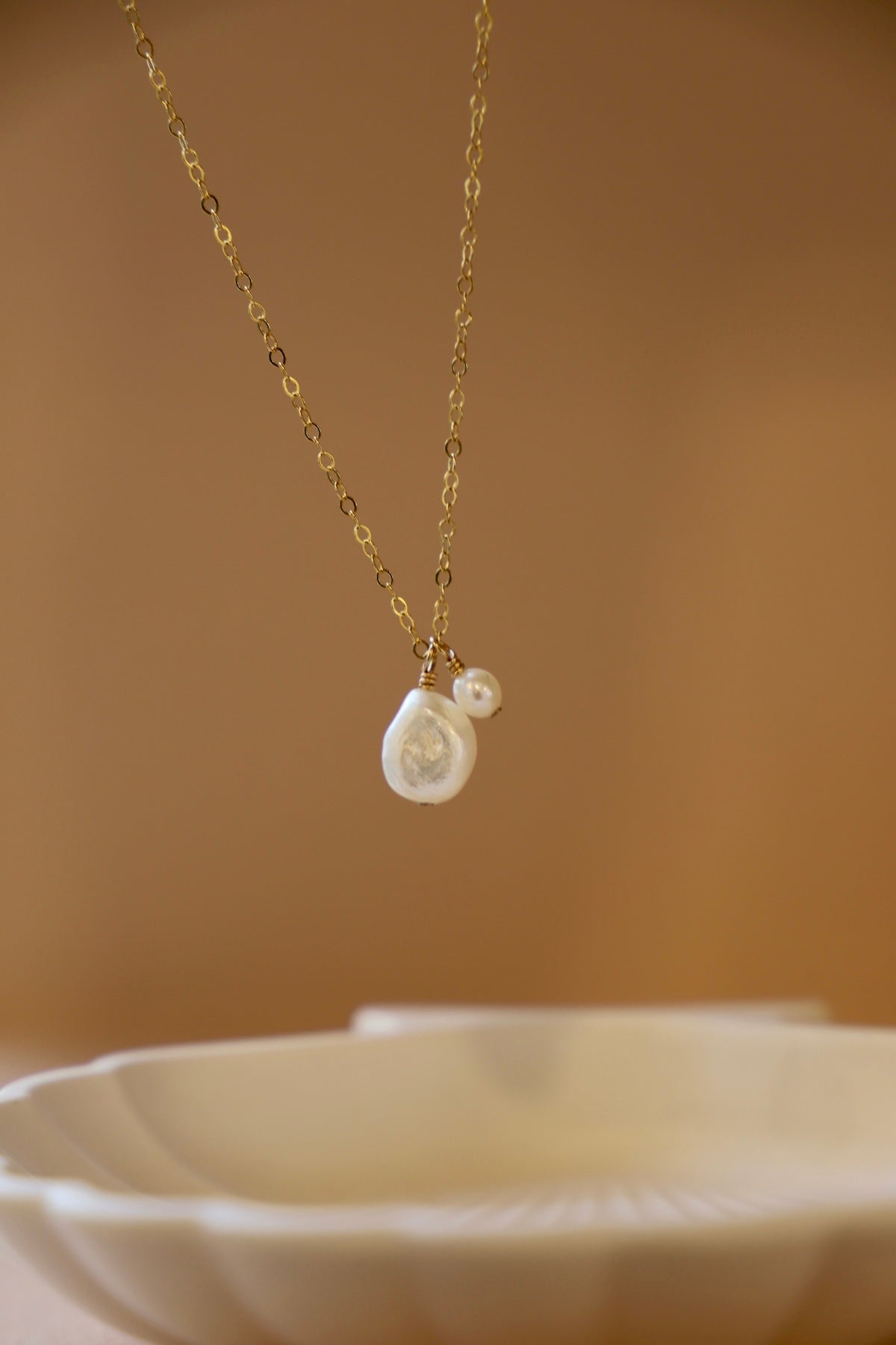Double Pearl Drop Necklace featuring delicate freshwater pearls on a sleek gold-toned chain, perfect for layering.