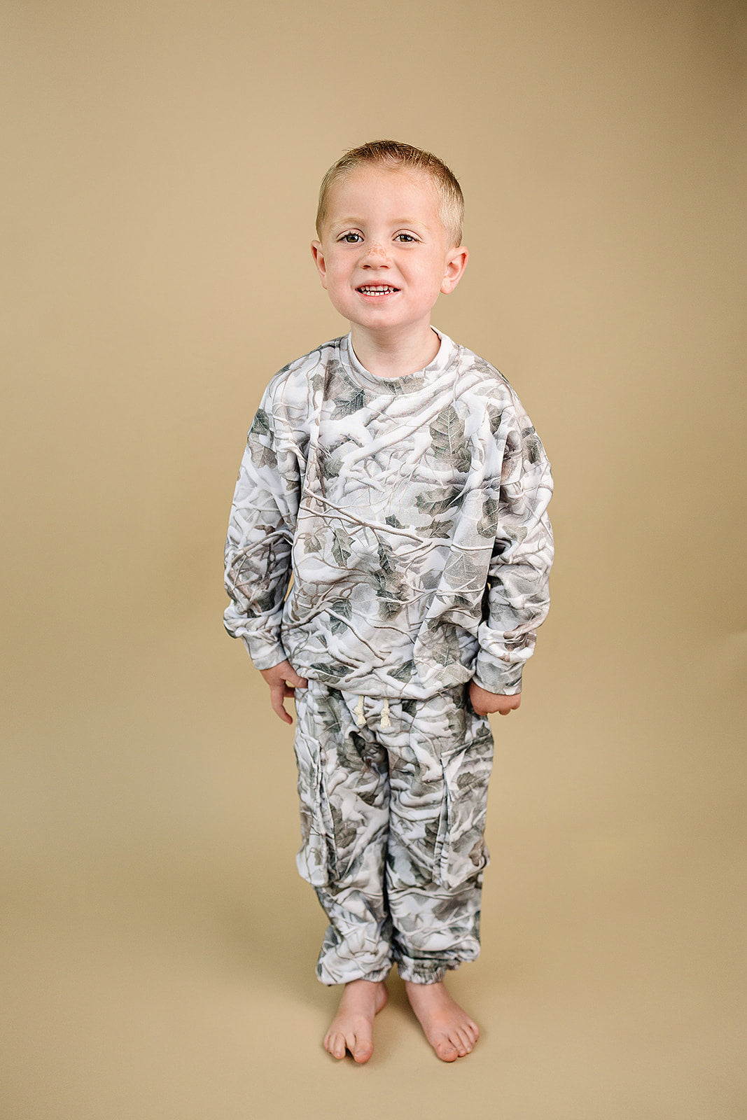 Young boy wearing Camo Kids Lounge Set with Cargo Joggers, featuring a camo pullover and matching joggers.