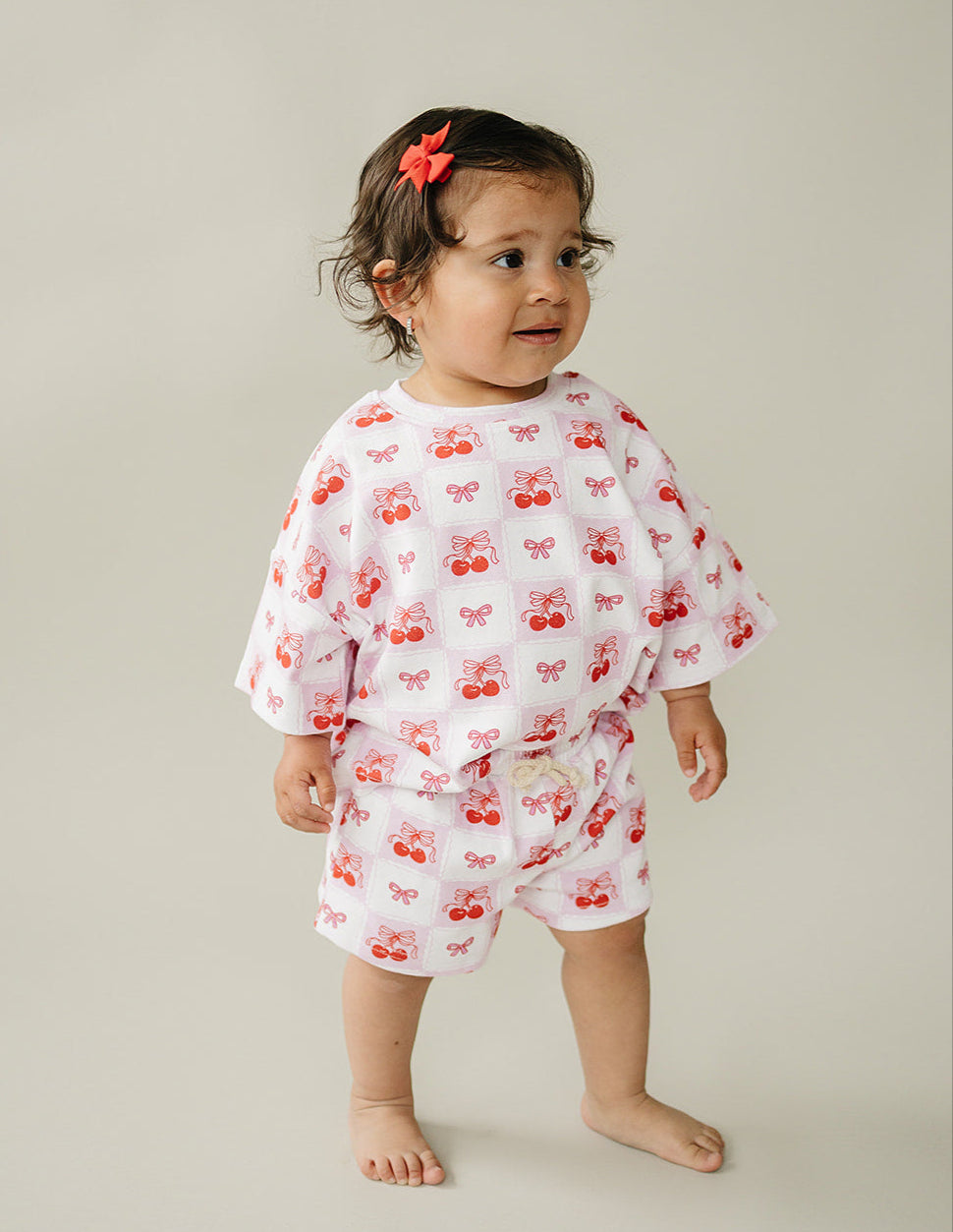 Toddler wearing Checkered Cherry shorts set with bow print, perfect for summer fun and retro vibes.