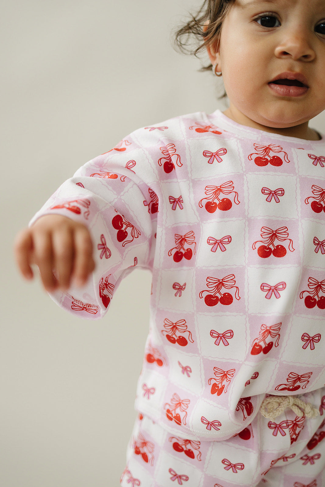 Toddler wearing a checkered cherry print shorts set, showcasing retro vibes and playful designs.