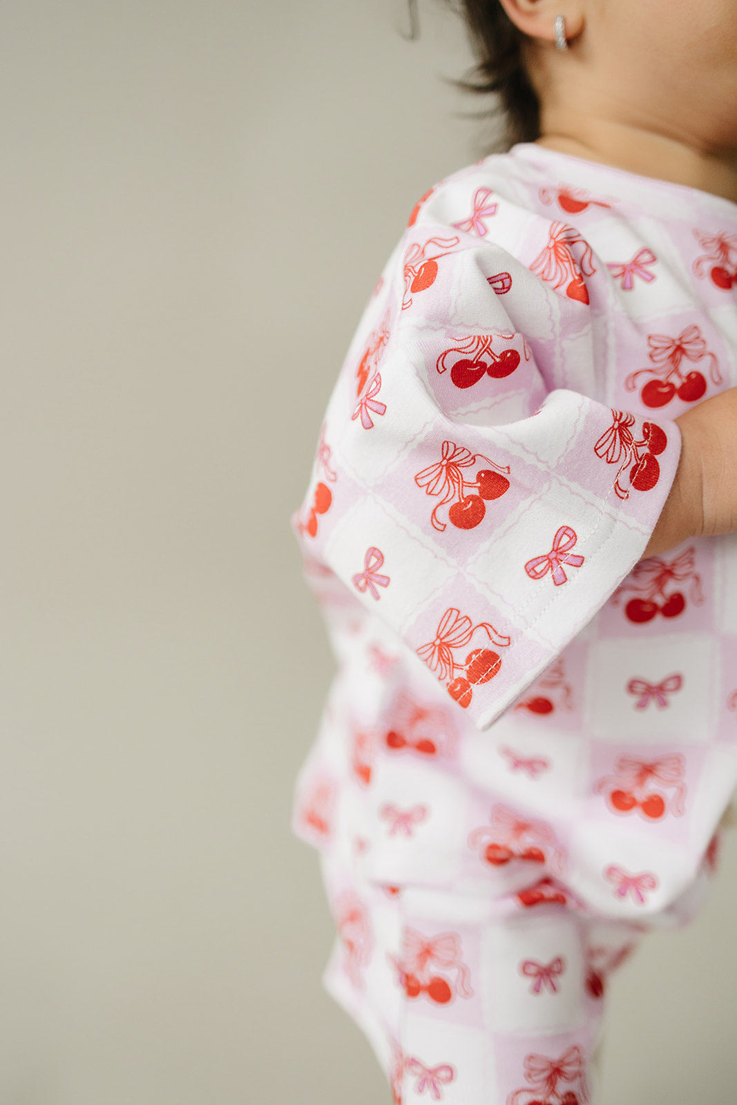 Toddler wearing a checkered cherry print shorts set, featuring playful cherry motifs and soft cotton blend fabric.