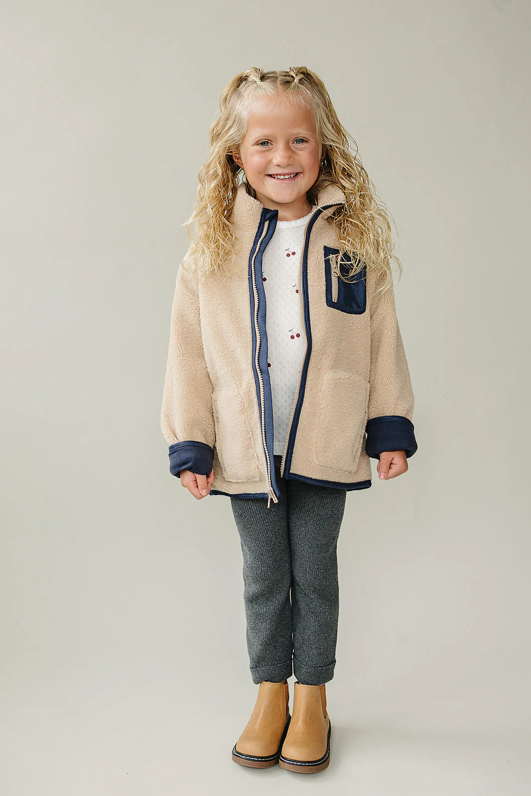 Baby and Kids Sherpa Zip-Up Jacket showcased on a smiling child, featuring a cozy hood and plush fleece material.
