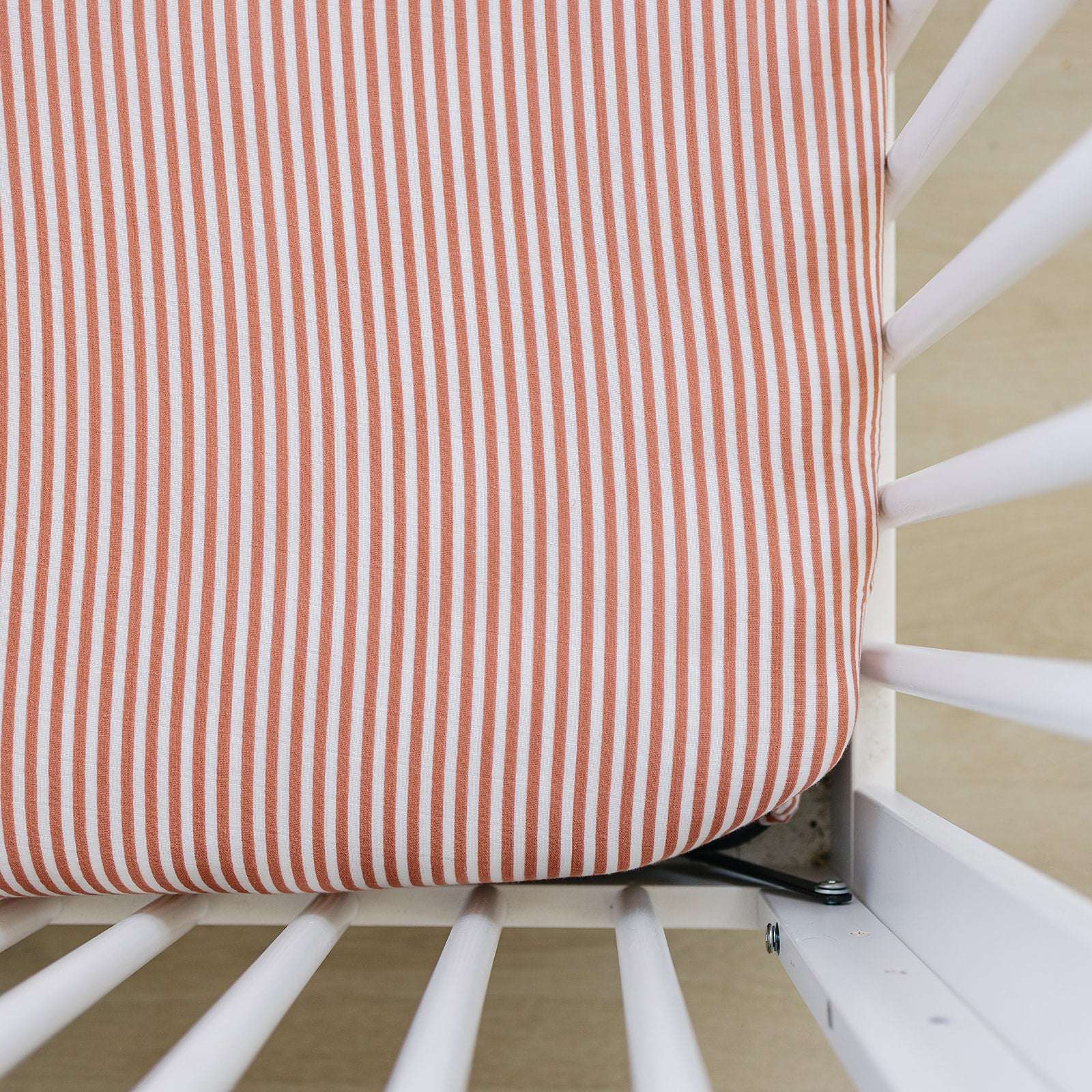 Muslin Crib Sheet - Pink Stripes on a crib mattress, made from soft breathable cotton muslin for comfort.