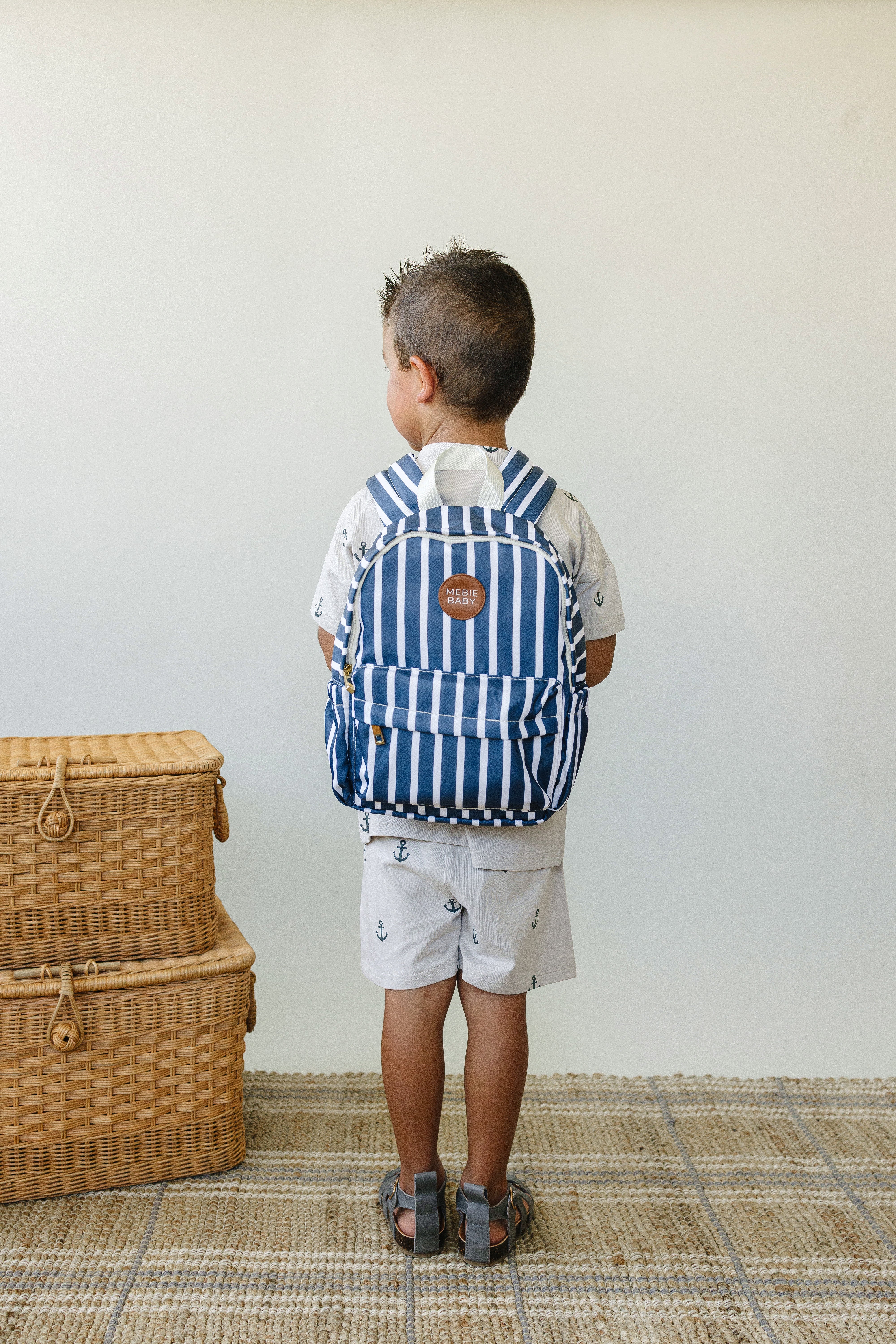 Child wearing a navy stripe mini backpack, perfect size for toddlers and kindergartners.