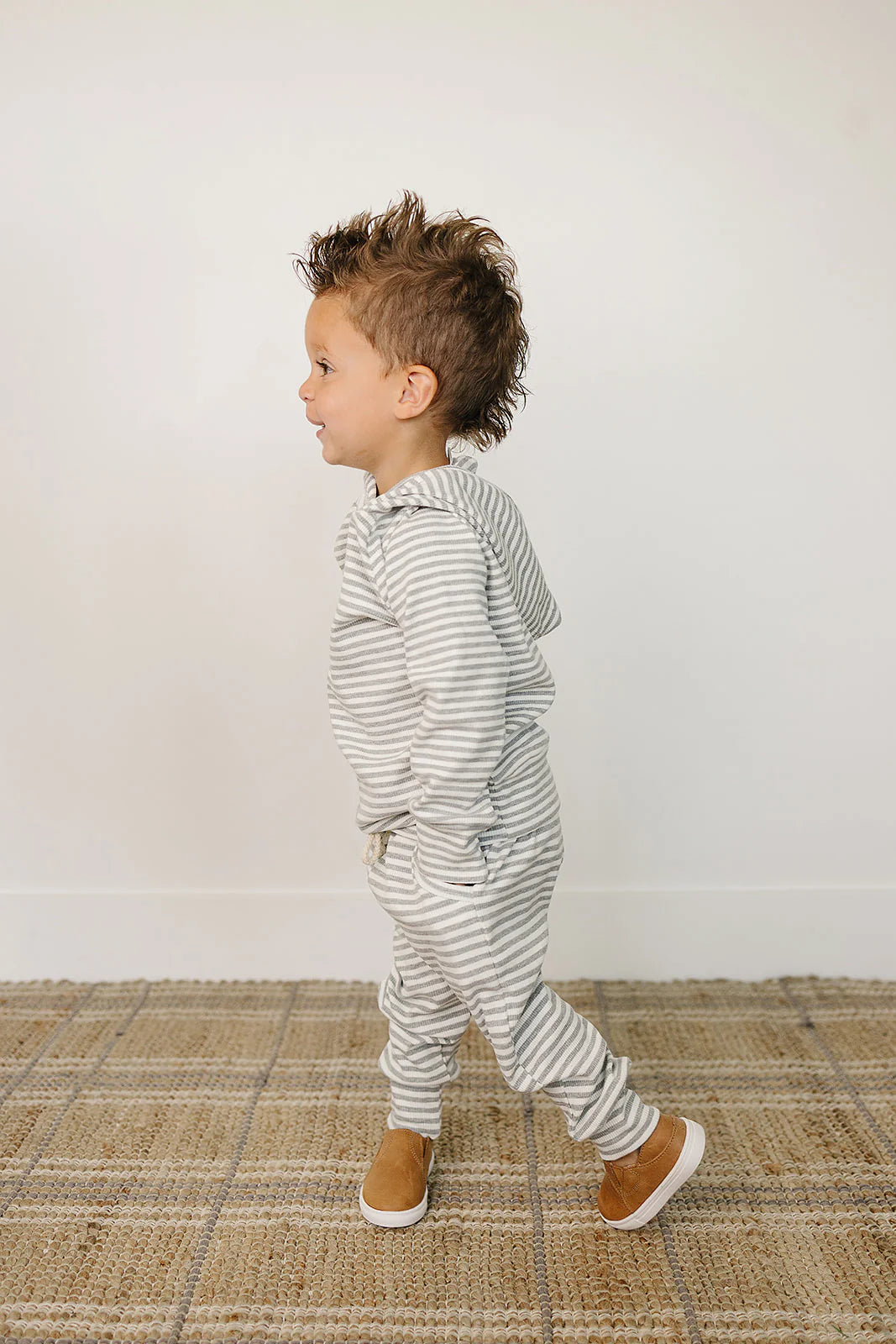 Grey striped baby and toddler lounge set on a child, showcasing comfort and style in knit fabric.