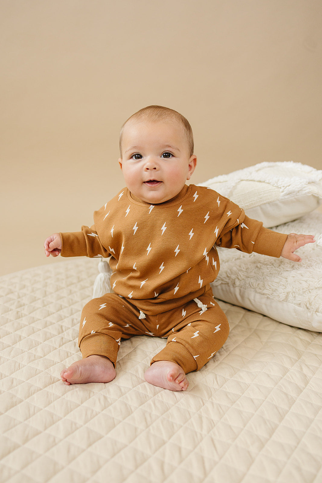 Baby wearing the Fall Bolts Kids Lounge Set, featuring a lightning bolt print in earthy tones.