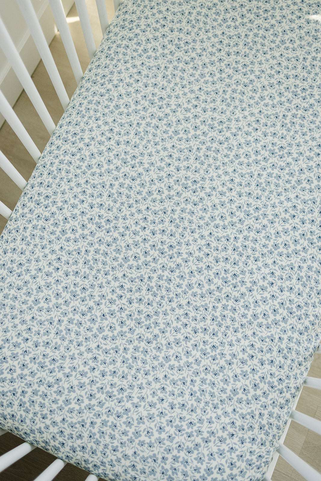 Muslin Crib Sheet - Blue Blossom design on a crib mattress, made from soft and breathable 100% cotton muslin.