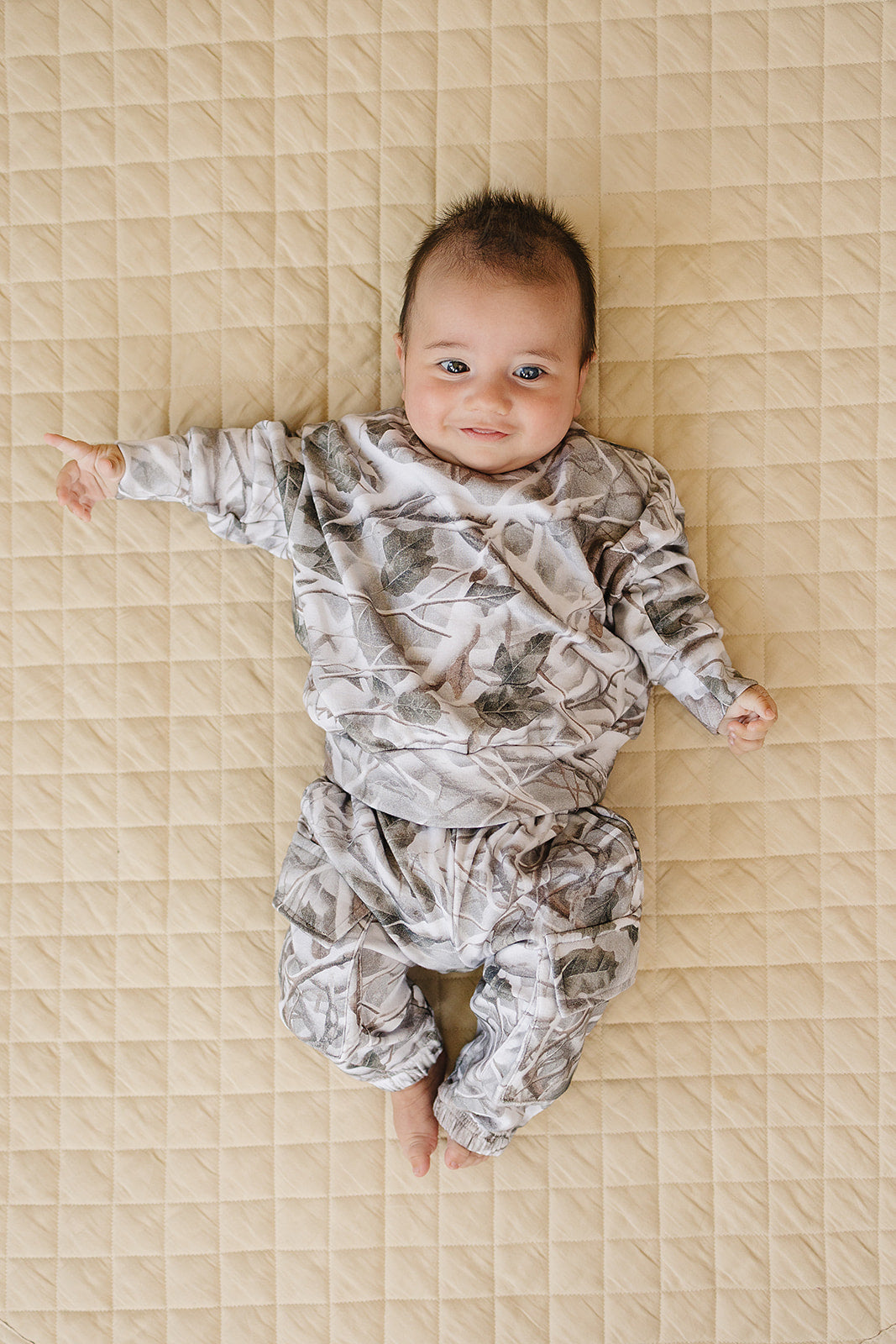 Camo kids lounge set showcased on a baby, featuring a pullover hoodie and matching cargo joggers in camo print.