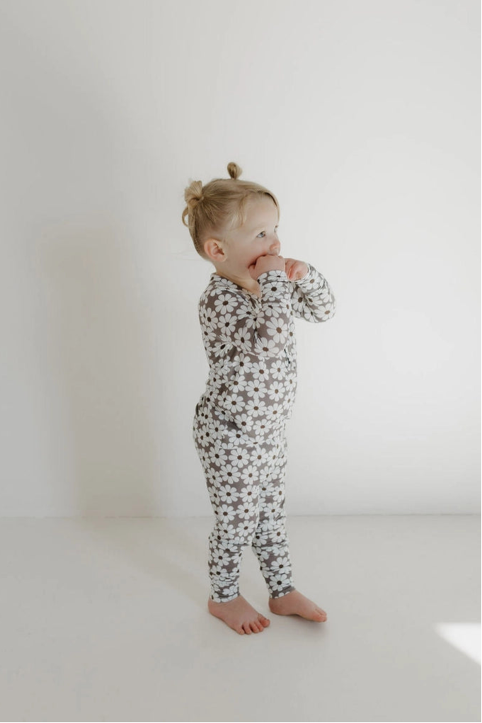 Cute child in bamboo two-piece pajamas darlin' with daisy print, showcasing comfort and style for kids.