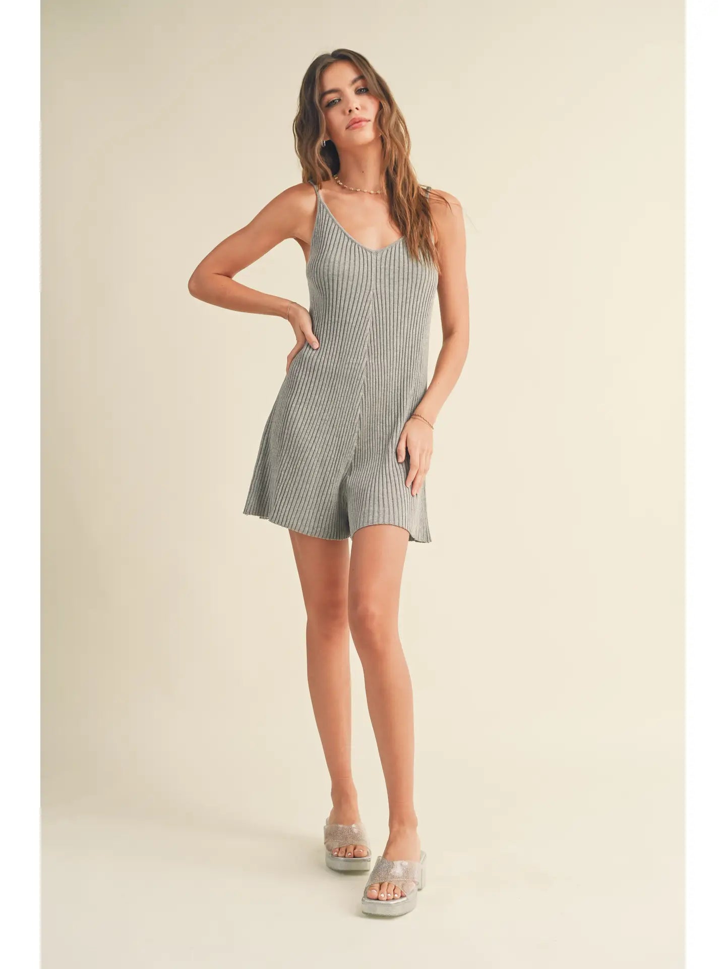 Model wearing a ribbed knitted romper in gray, showcasing a flattering fit and casual style.