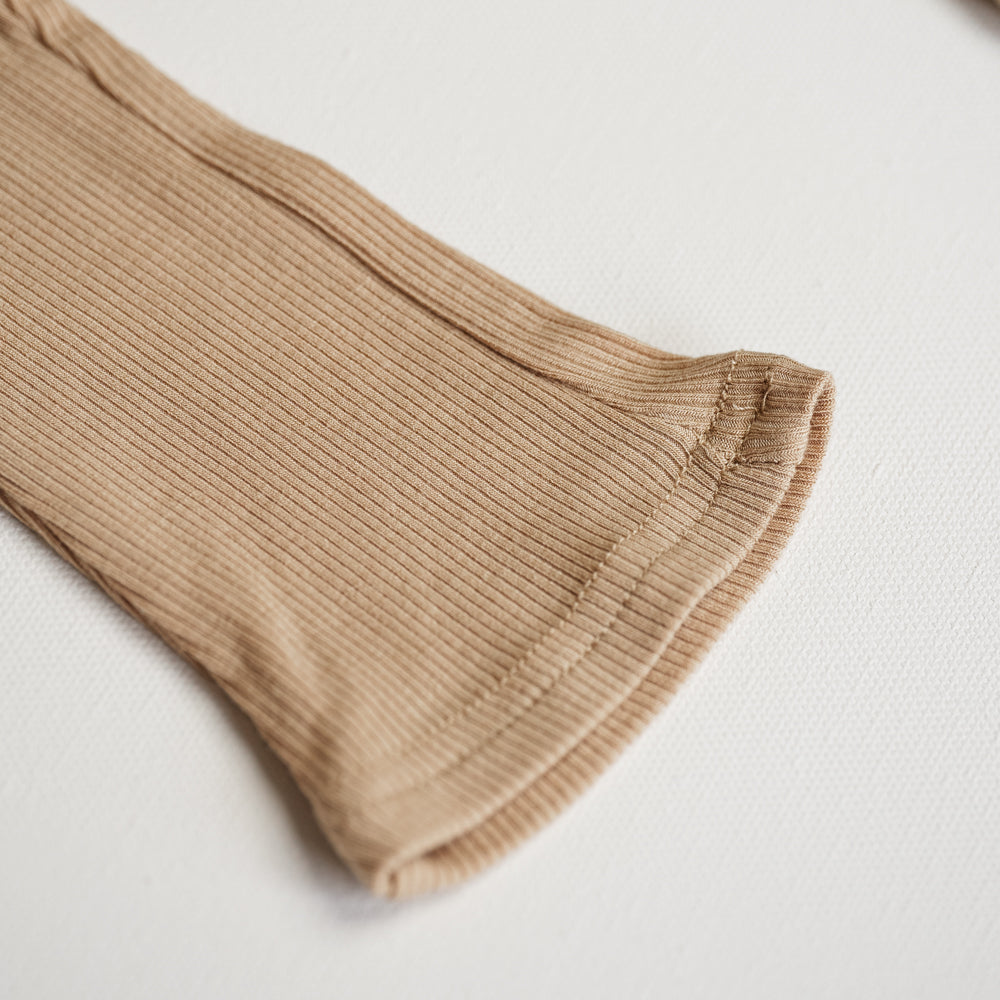 Close-up of Ribbed Modal Flare Pant showcasing its soft ribbed texture and neutral color.