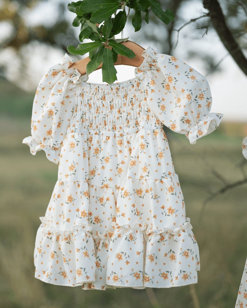 Katherine Dress in yellow floral, smocked bodice and flutter sleeves, perfect for twirling on sunny days.