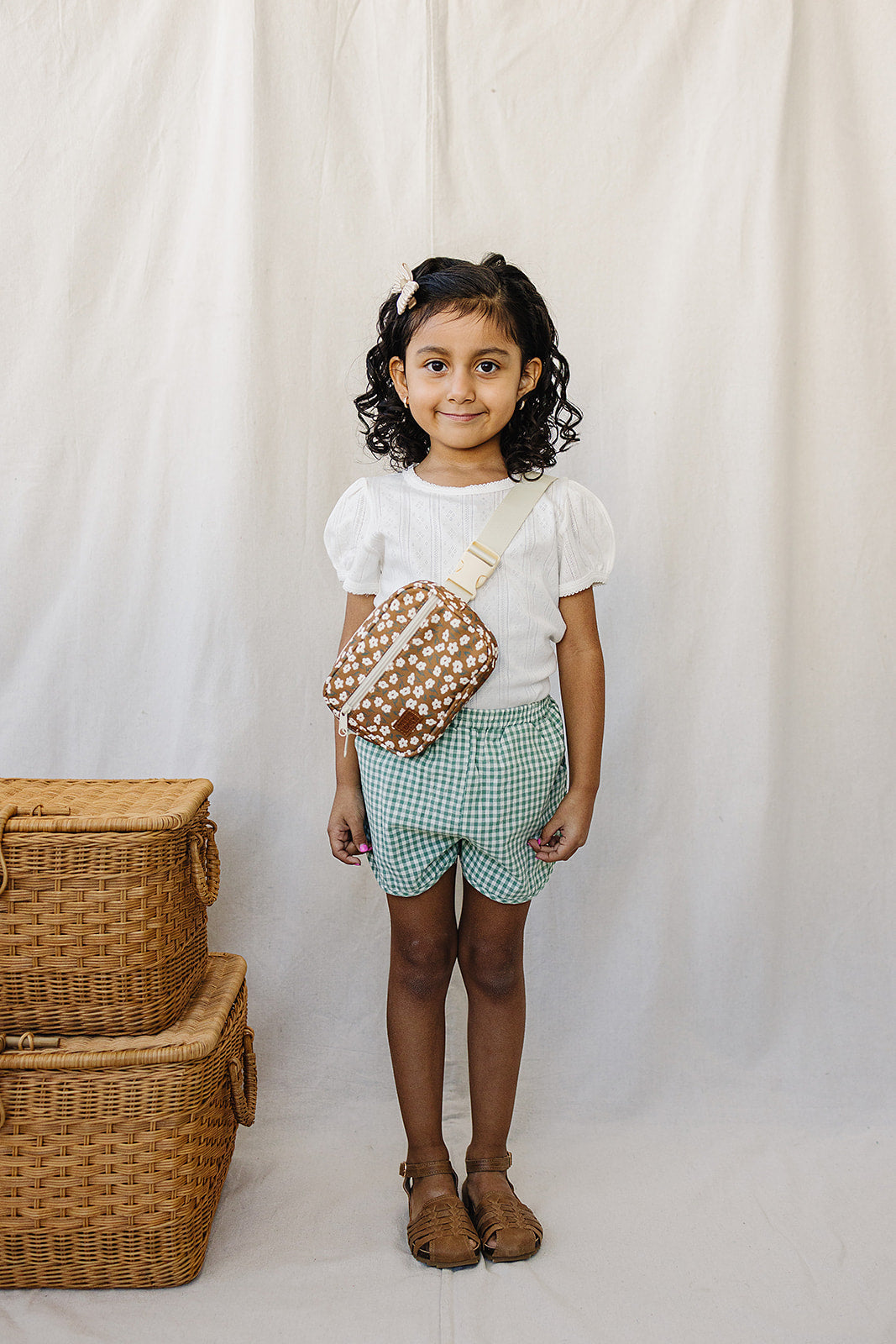 Toddler wearing a vintage floral mini fanny pack, styled with a white top and green checkered shorts.