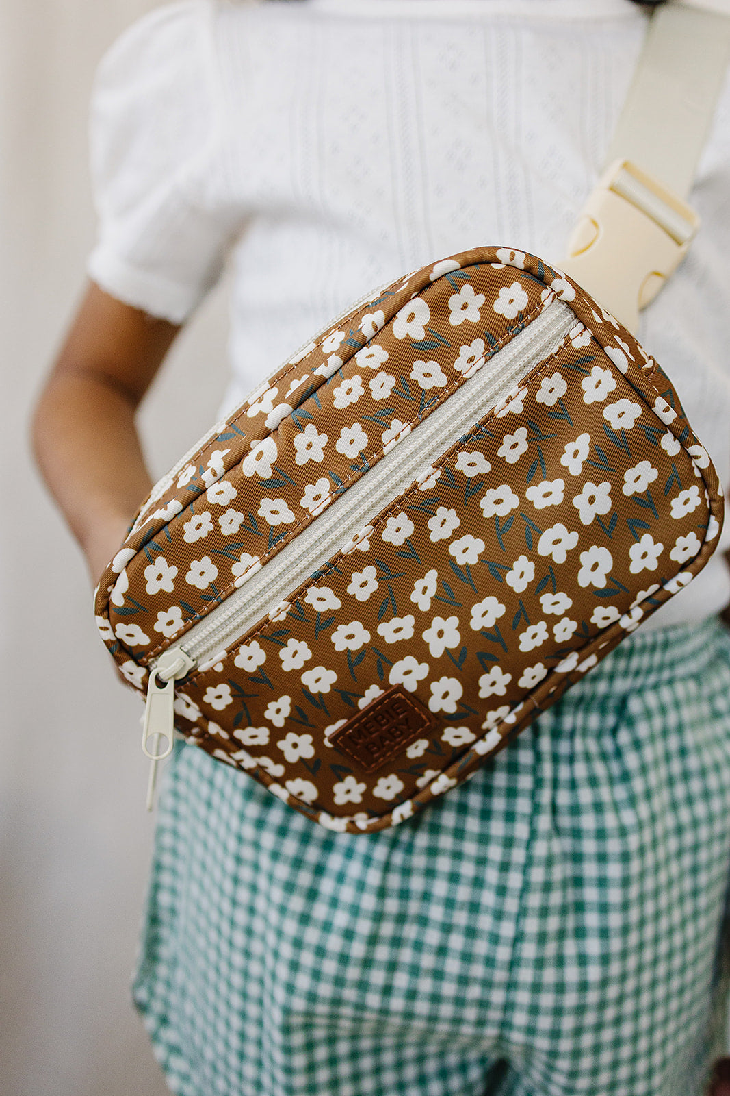 Mustard floral mini fanny pack worn by a child, featuring vintage floral print and adjustable strap.